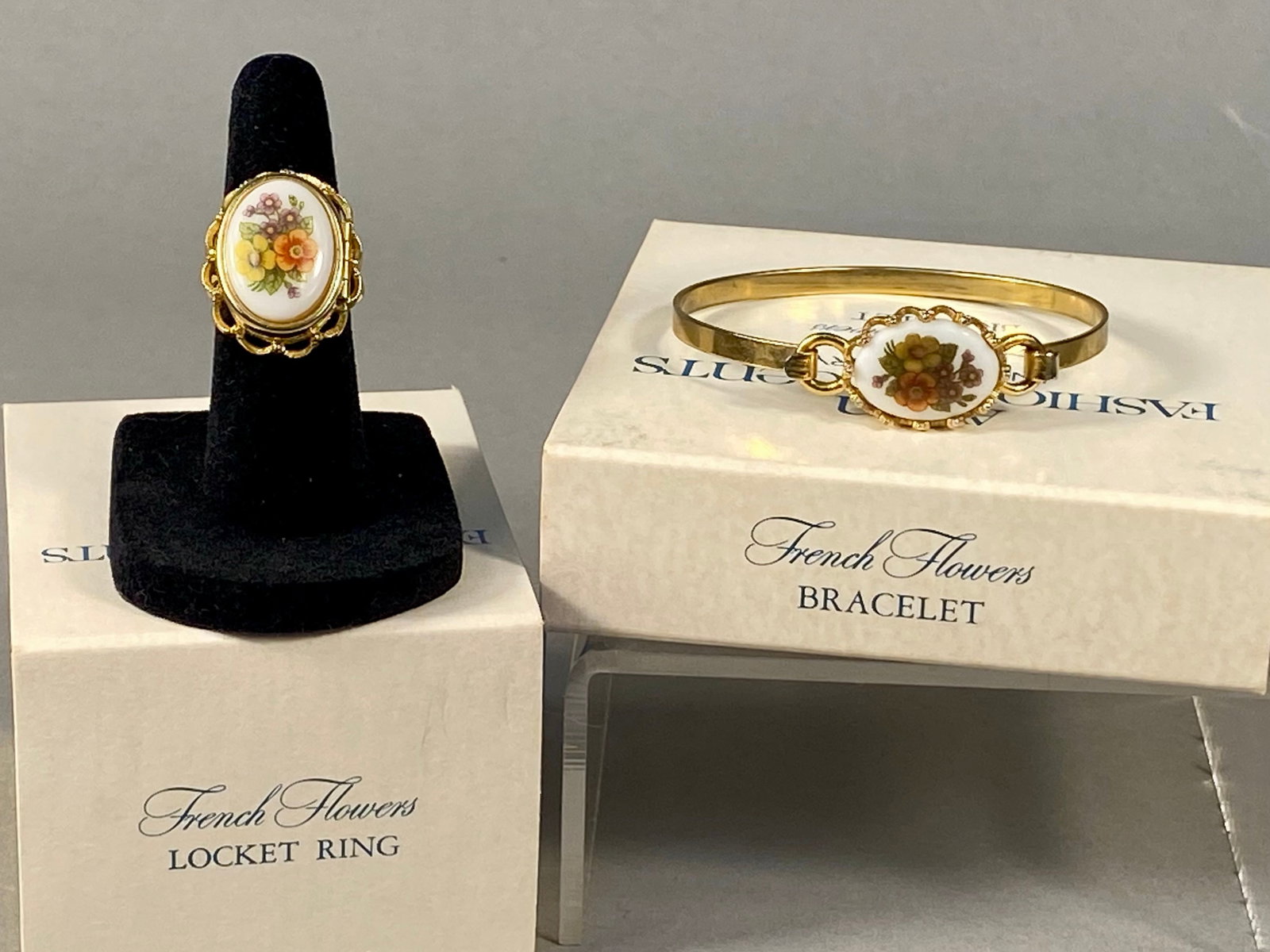 Avon 1975 French Flowers Bracelet and Locket Ring: This set includes a locket ring and bracelet from the 1975 Avon French Flowers collection. Both pieces are constructed from yellow gold-tone base metal and feature central oval-shaped white inserts de