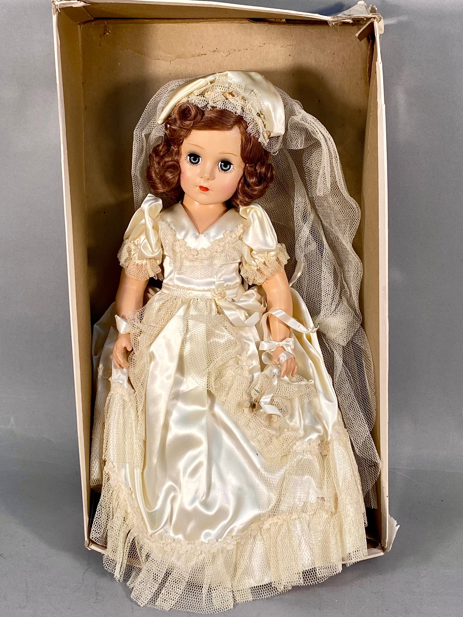 De Soto Manufacturing Co. Composition Bride Doll: This 18-inch composition bride doll was manufactured by the De Soto Manufacturing Co. of Chicago, Illinois. The doll features a composition head and limbs with blue sleep eyes and full eyelashes. It r