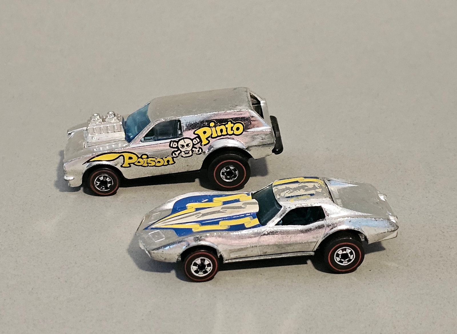 Hot Wheels Redline Die-Cast Cars: This lot consists of two die-cast toy cars from the Mattel Hot Wheels Super Chromes series, manufactured in Hong Kong. Both vehicles feature the characteristic redline wheels of the era. The first car