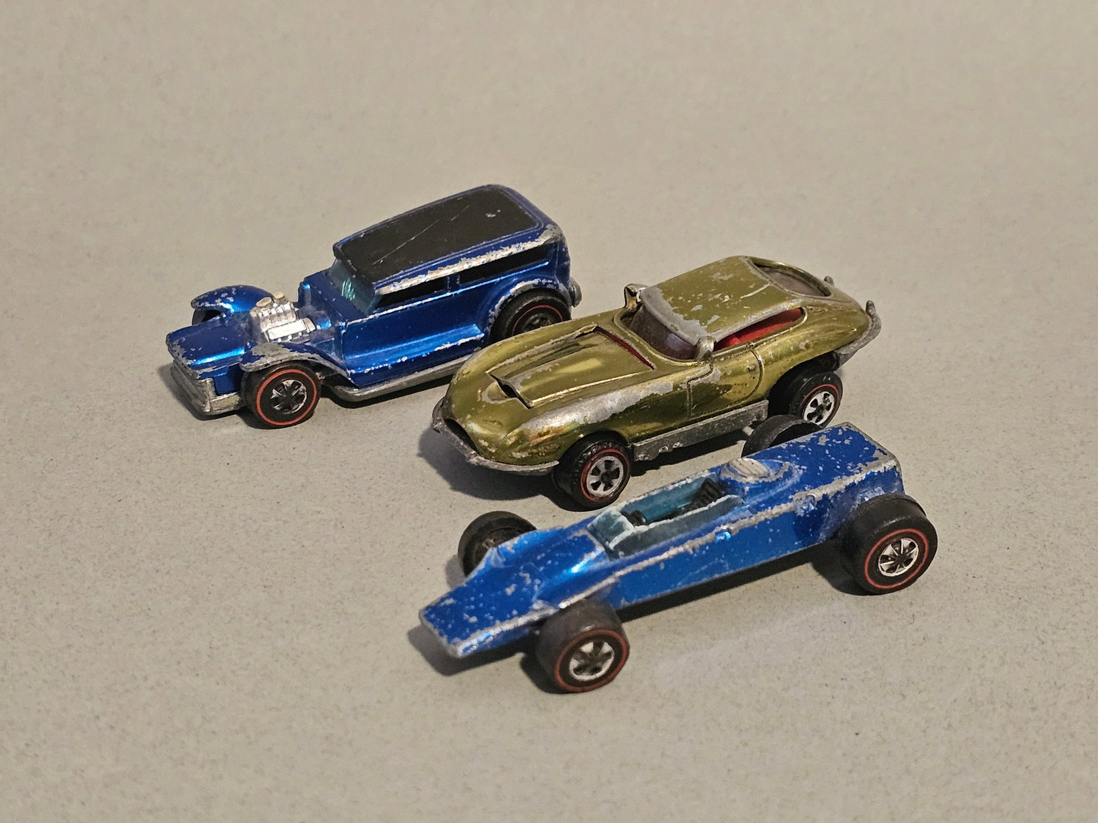 Three Vintage Toy Cars: This lot consists of three vintage vehicles produced in the late 1960s and early 1970s, featuring die-cast metal bodies and chassis with plastic wheels and interior components. Two Mattel Hot Wheels c