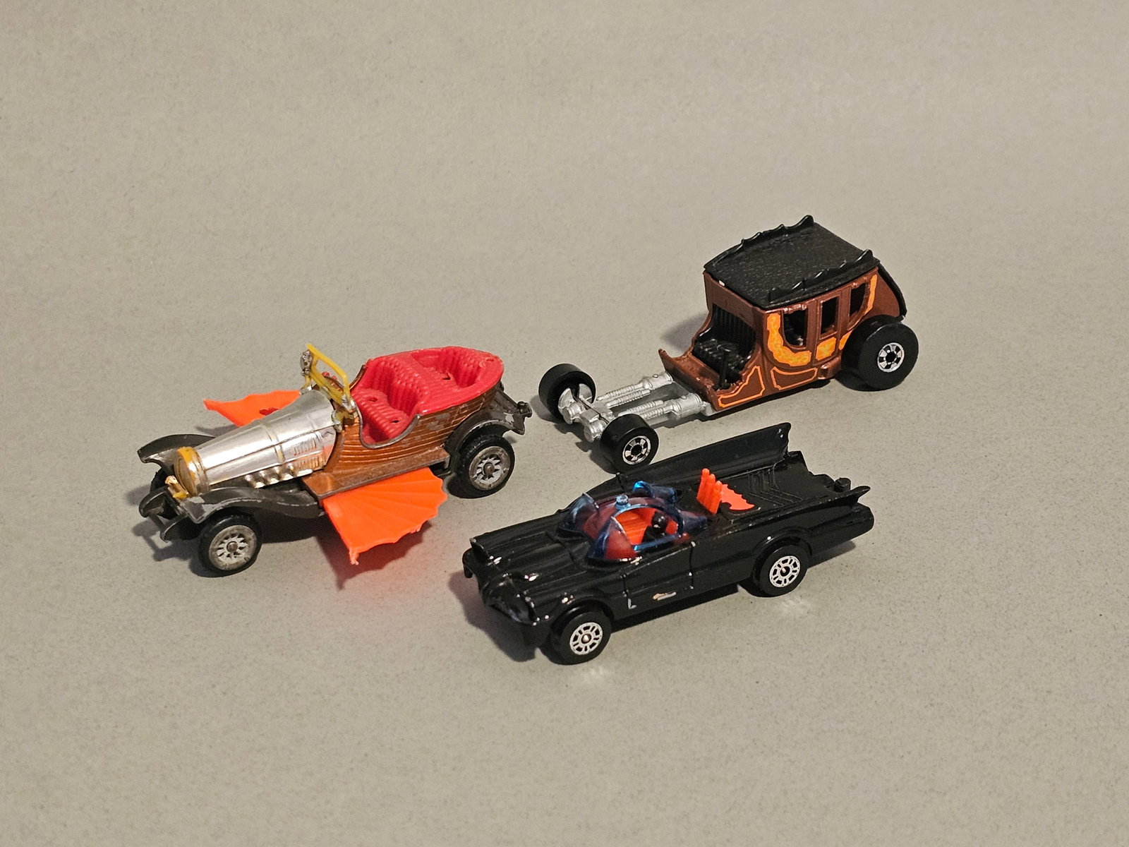 Three Vintage Die-Cast Toy Vehicles: This collection consists of three vintage die-cast toy vehicles produced by Husky, Corgi Juniors, and Hot Wheels. Each car measures 2.5-3 inches in length. These items are in played-with condition con