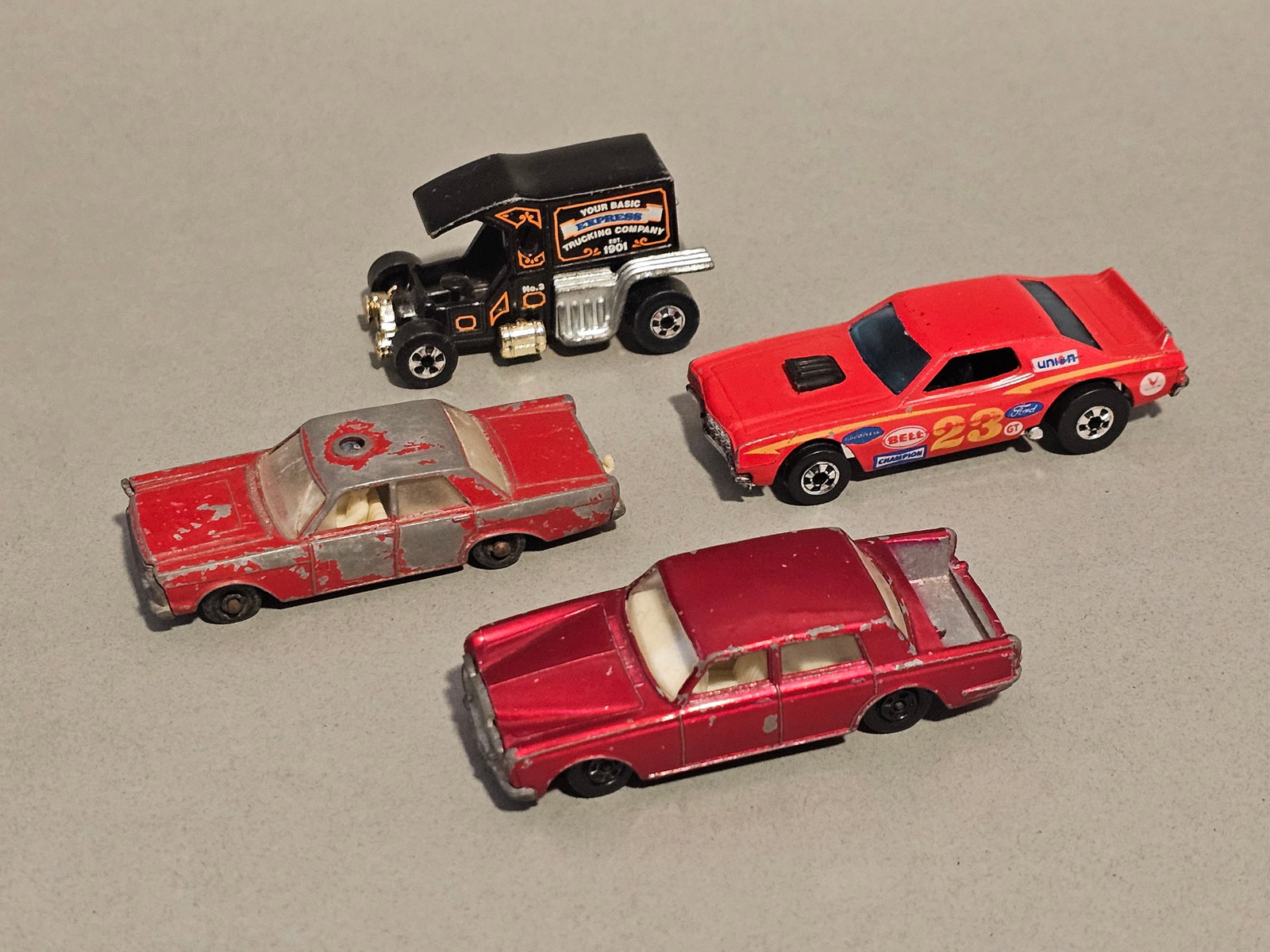 Vintage Matchbox and Hot Wheels Vehicles: A group of four vintage die-cast metal toy vehicles manufactured by Mattel and Lesney. All vehicles are constructed with die-cast metal bodies and plastic components. Each car measures 2-3 inches in l