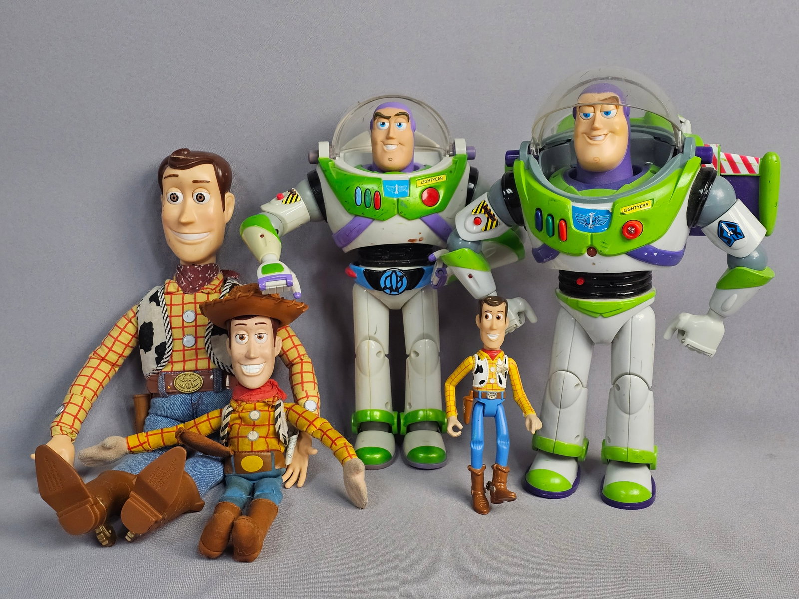 Toy Story Woody and Buzz Lightyear Action Figures: This lot features a collection of items from the Toy Story franchise depicting the characters Woody and Buzz Lightyear. Measurements range from 6-16 inches tall. All items are in play-worn condition w