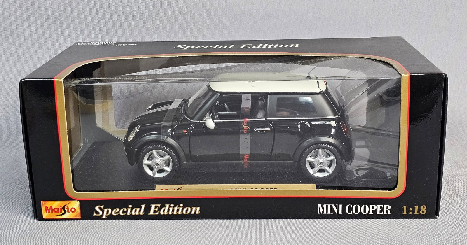 Maisto Special Edition 1:18 Scale Mini Cooper: Maisto Special Edition 1:18 scale die-cast model of a Mini Cooper, product number 31619 in box. This model is constructed from die-cast metal with plastic components. The vehicle features a gloss blac