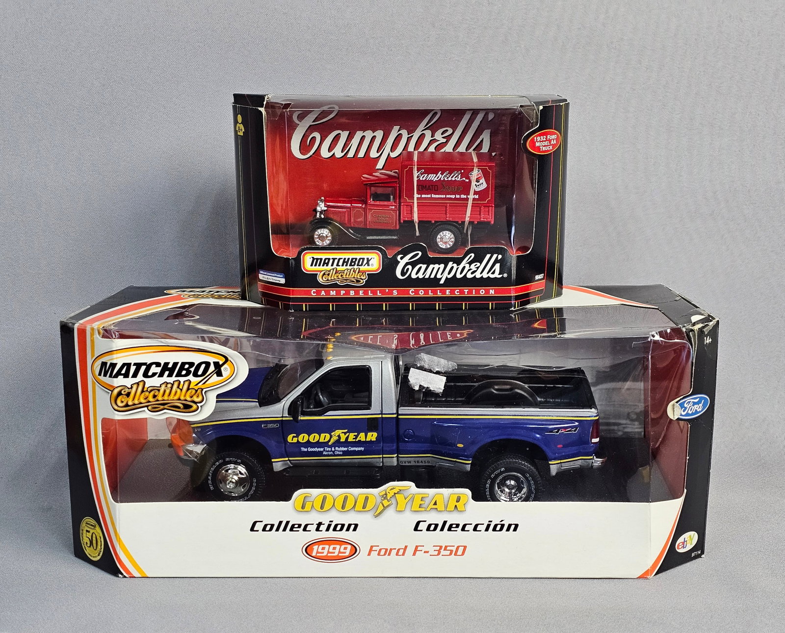 Pair of Matchbox Collectibles Trucks in Boxes: This lot includes a pair of die-cast metal vehicles produced by Matchbox Collectibles, a division of Mattel, Inc. The first vehicle is a 1999 Ford F-350 dual-rear-wheel pickup truck from the Goodyear 