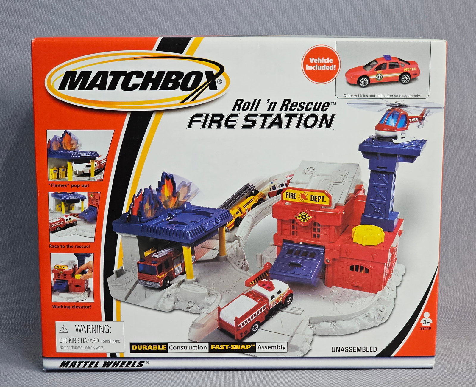 Matchbox Roll 'n Rescue Fire Station Playset: A Mattel Matchbox Roll 'n Rescue Fire Station playset, model number 88449. The set is constructed primarily from molded plastic and features several interactive components including a Fast-Snap assemb