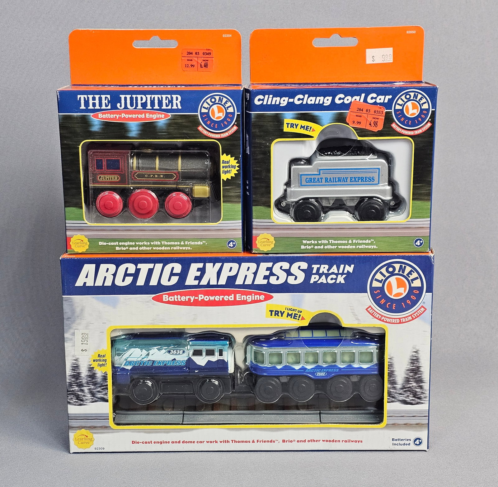 Three Lionel Battery-Powered Railway Toys in Boxes: A trio of vintage battery-powered wooden railway toys from the Lionel Battery-Powered Train System line, manufactured by Learning Curve International, Inc. These items are designed for use with
