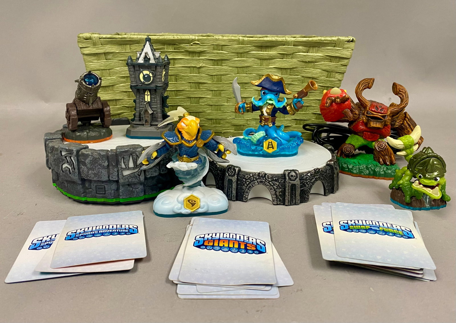 Activision Skylanders Figures, Portals of Power & Trading Cards: The group includes electronic Portal of Power units equipped with integrated USB cables. One portal features the green-rimmed base from the original series, while the second features a grey stone-text