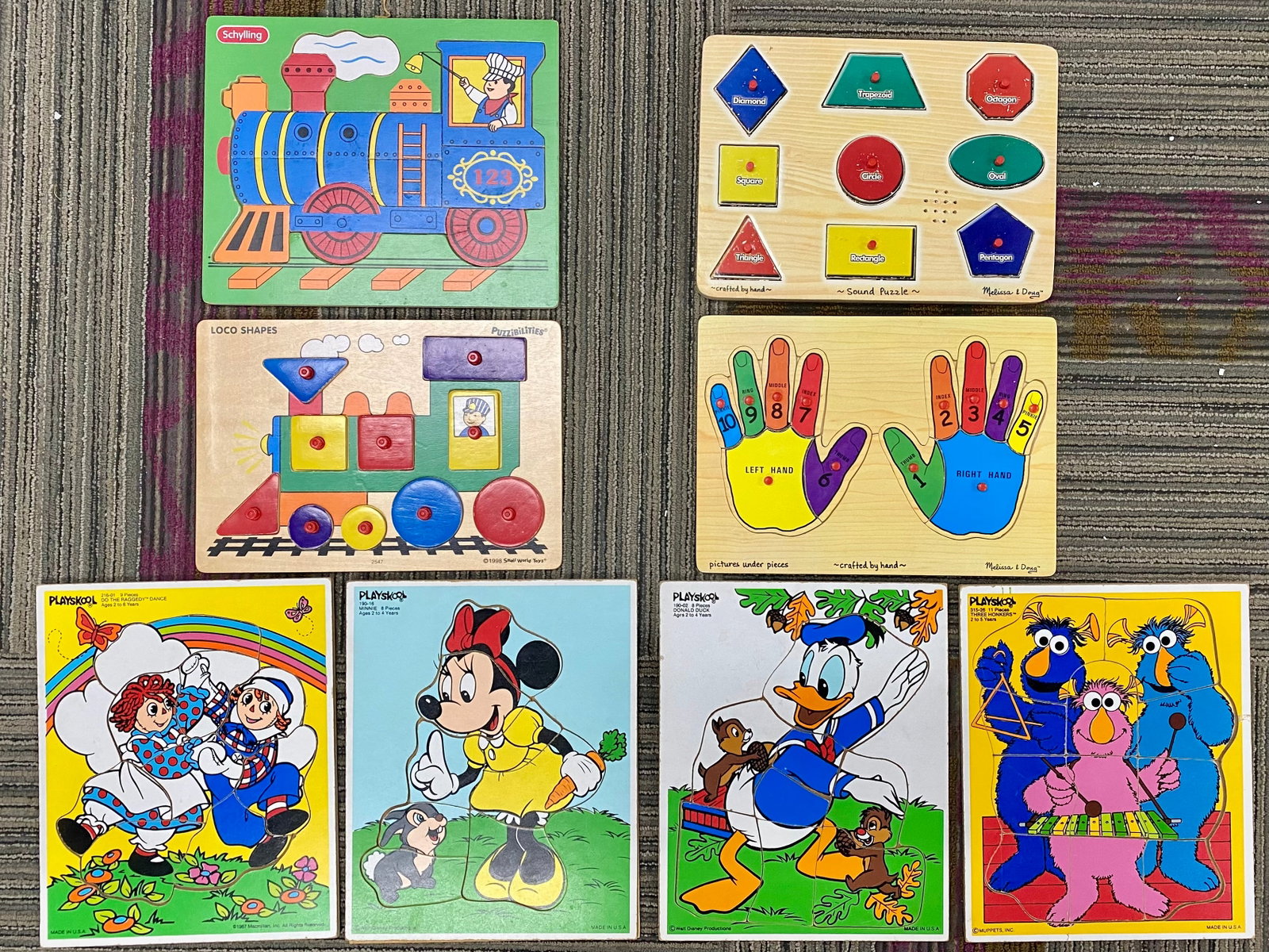 Eight Vintage Children's Wooden Puzzles: This collection of eight vintage wooden puzzles features a variety of themes including popular characters, shapes, and transportation. The group is composed of puzzles from several manufacturers, cons
