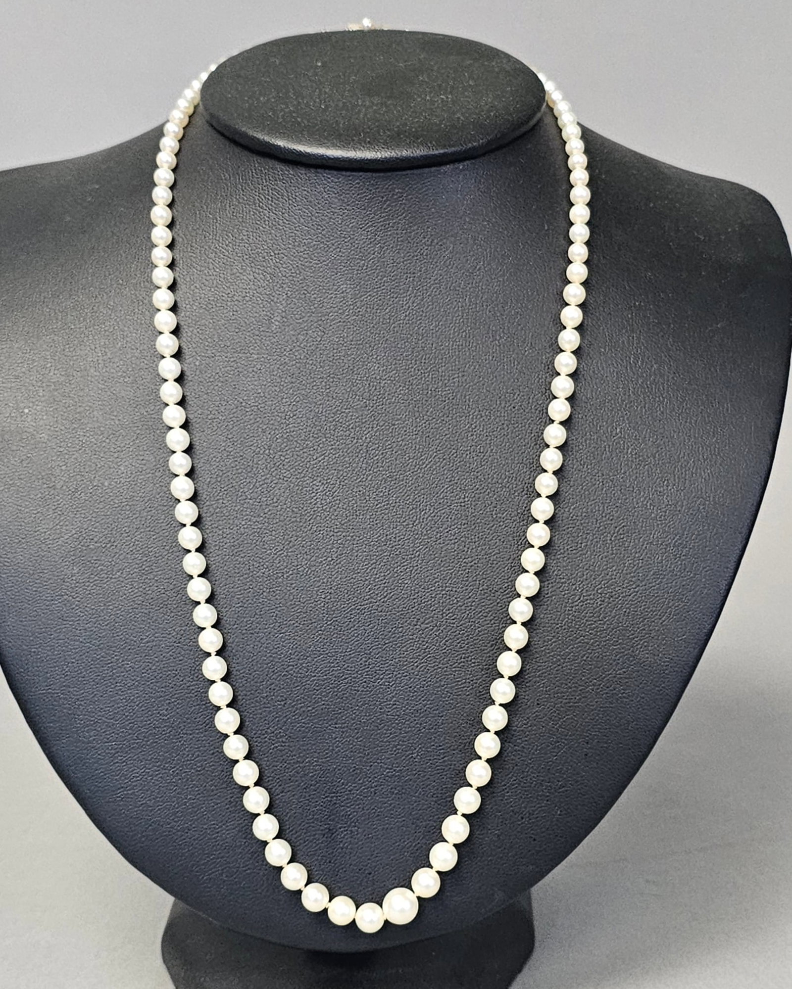 Mikimoto Graduated Cultured Pearl Necklace: This single strand graduated cultured pearl necklace is by Mikimoto. The necklace features cultured pearls with white body color and creamy overtones that exhibit a soft luster. The pearls are graduat