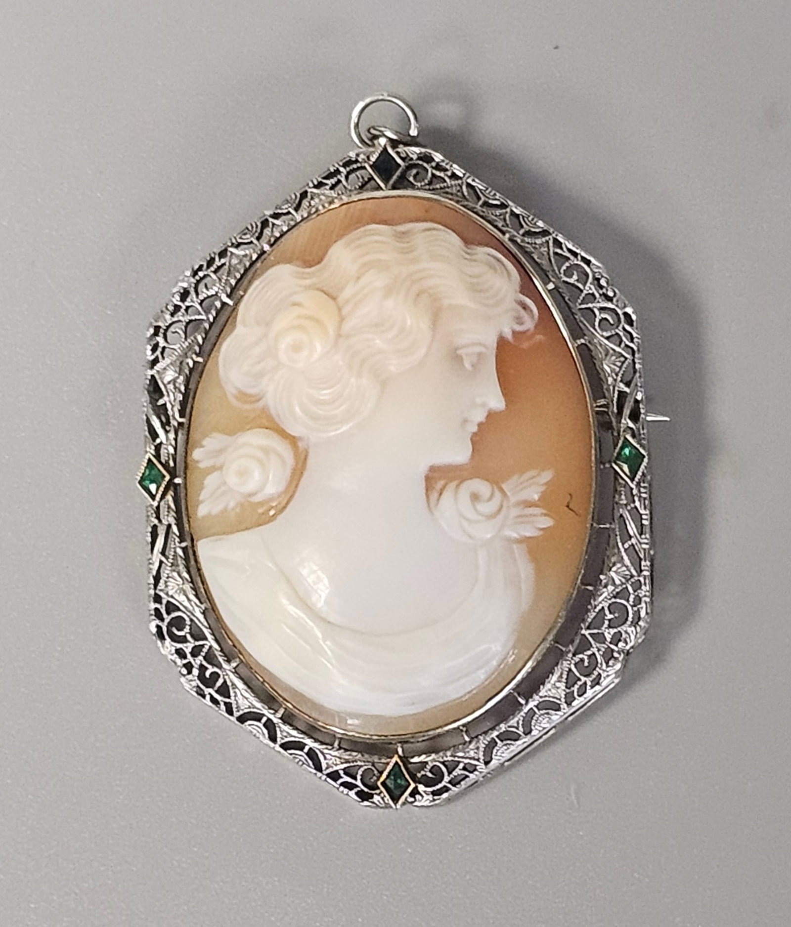 Art Deco 14K Carved Shell Cameo 11.2 Grams: This Art Deco period convertible jewelry piece functions as both a brooch and a pendant, crafted in 14 karat gold. The frame is decorated with delicate openwork, geometric piercings, and engraved flor