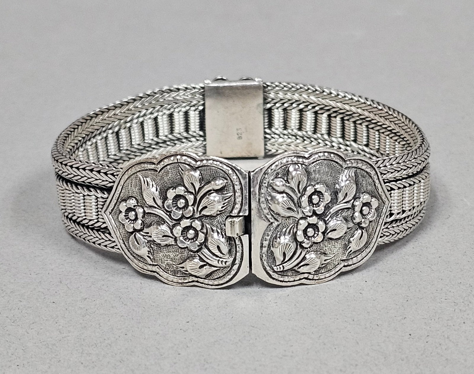 Sterling Silver Floral Repousse Bracelet 52.3 Grams: A wide sterling silver bracelet featuring a flexible band composed of four parallel rows of woven wheat-link chains. The interior of the clasp plate is stamped with the characters 925. Length: Approxi