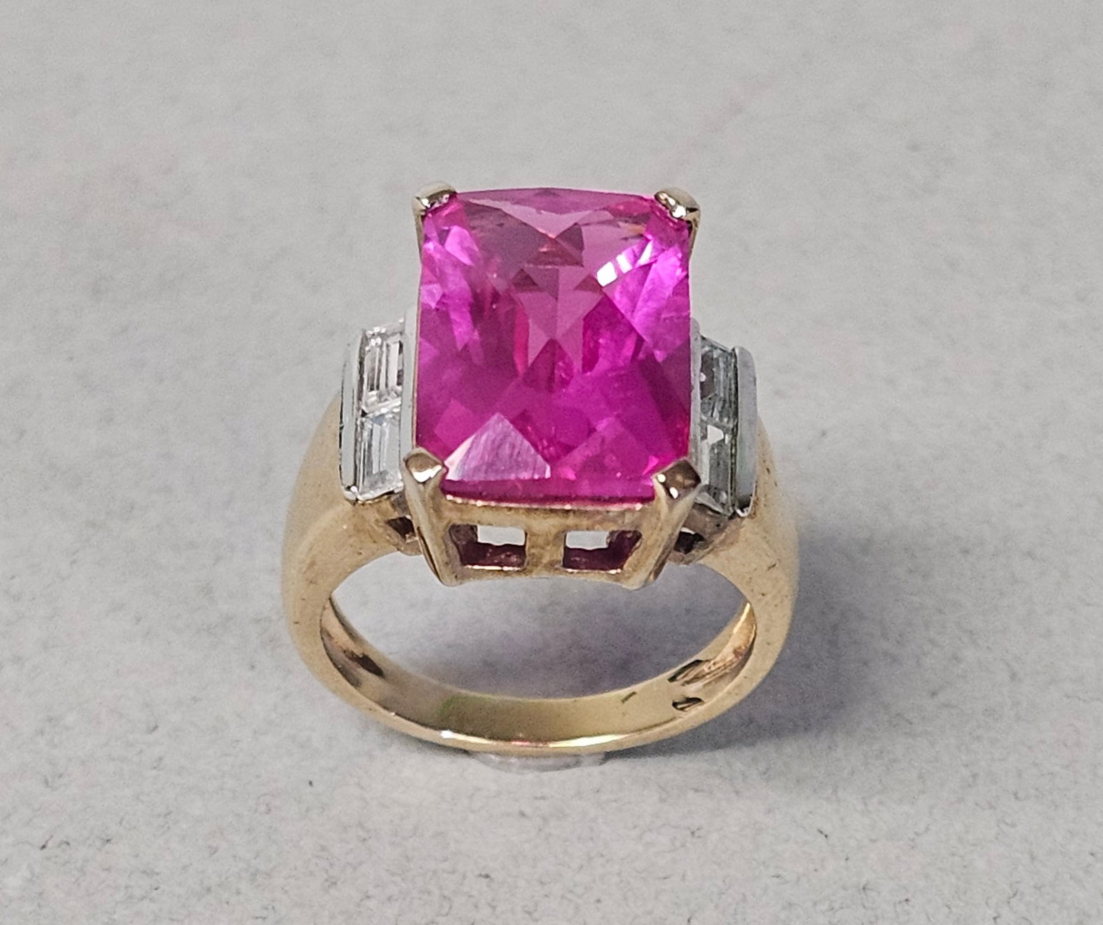 Gold-Plated Sterling Pink & Colorless Stones Ring 6.7 Grams: A large Gold Plated Sterling Silver Cocktail Ring. The center is set with a single large, rectangular-cut modified emerald or scissor-cut vibrant pink gemstone held in a four-prong raised basket. Size