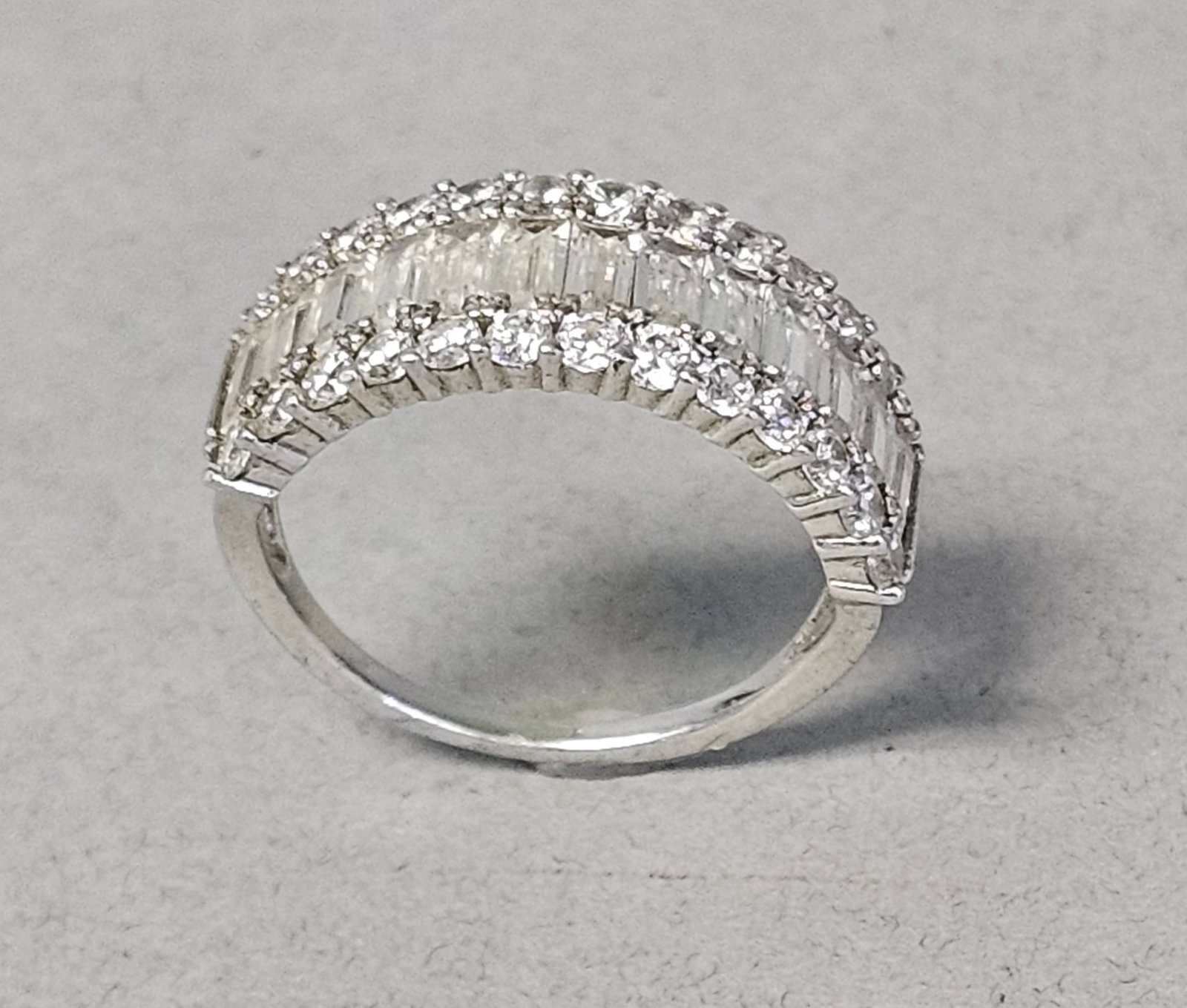 Sterling Colorless Stone Ring 3.3 Grams: This sterling silver multi-row band ring is produced by International Bullion and Metal Brokers (IBB). The design features three parallel rows of colorless stones. The center row consists of