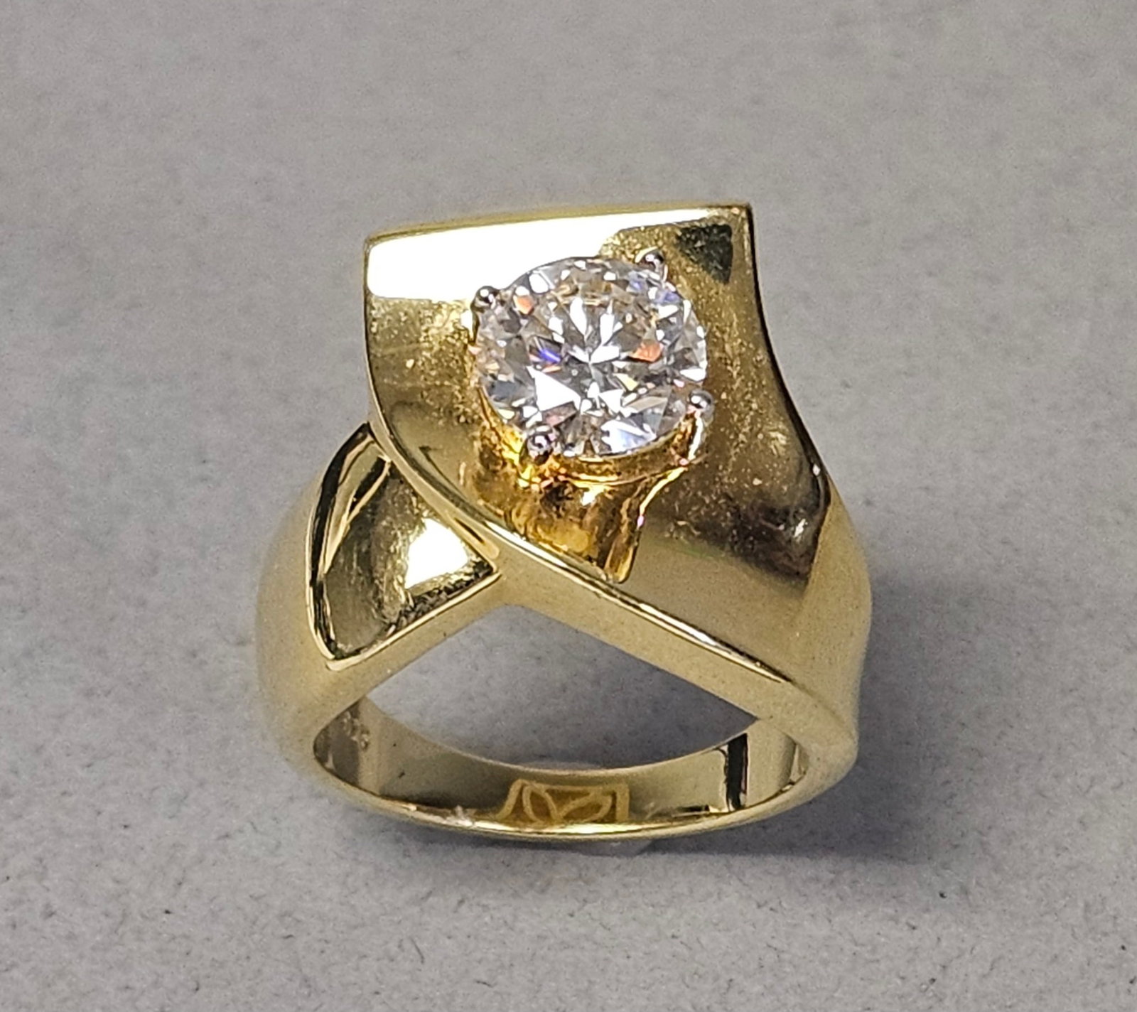 PAJ Gold-Plated Sterling Colorless Stone Ring 8.8 Grams: A contemporary wide bypass ring crafted in yellow gold-plated sterling silver. The piece features a large, prong-set round brilliant-cut colorless stone measuring approximately 8.5mm in diameter. The 