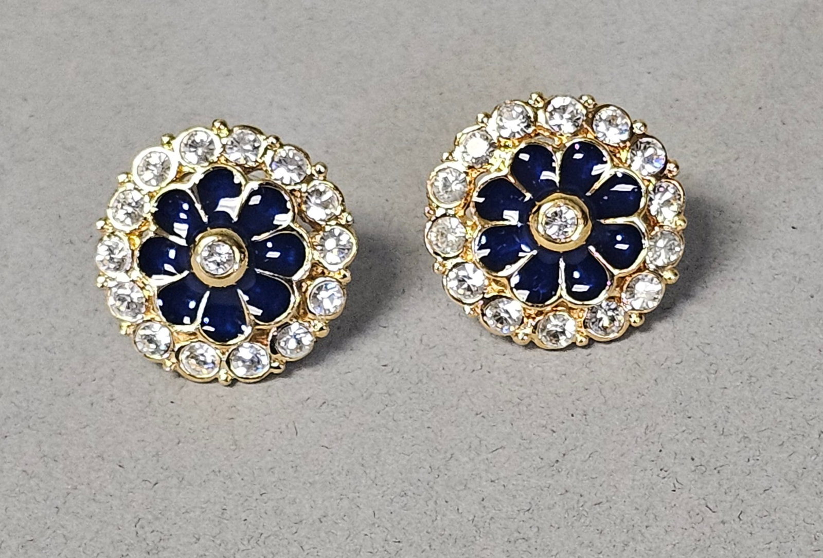 Camrose & Kross Jacqueline Kennedy Earrings: A pair of gold-tone costume jewelry stud earrings from the Camrose & Kross Jacqueline Bouvier Kennedy (JBK) collection, known as the Grand Tour Single Petal design. Each earring features a central eig
