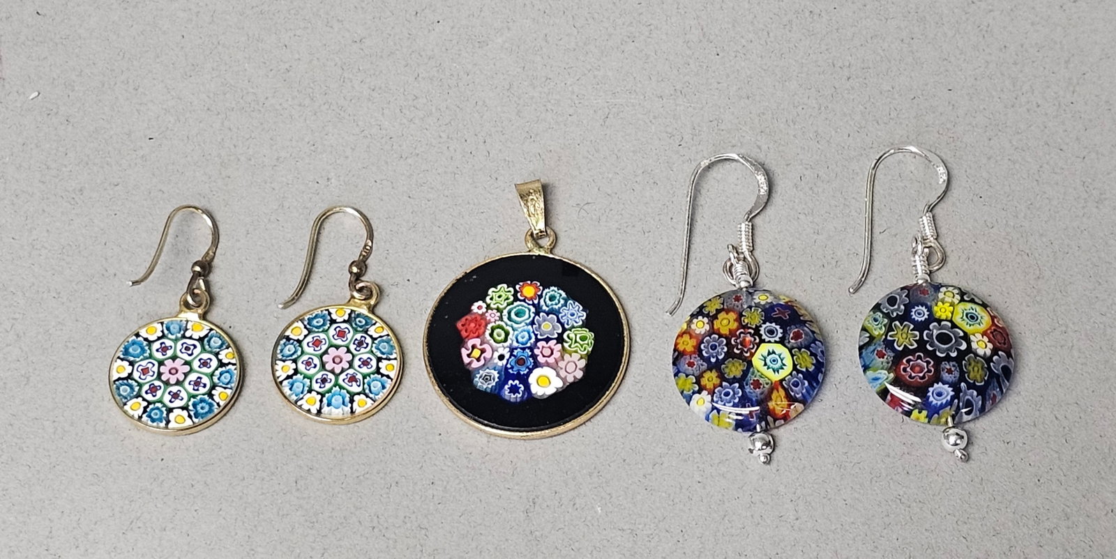 Sterling Silver & Vermeil Millefiori Glass Jewelry: A collection of millefiori glass jewelry comprising two pairs of drop earrings and one circular pendant. The pieces feature multi-colored floral millefiori glass canes bezel-set in metal. Stamped