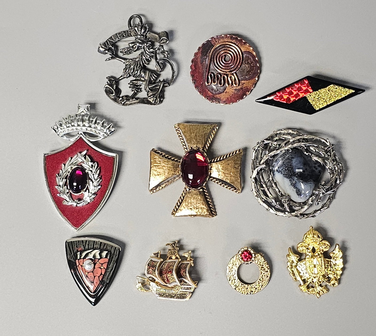 Vintage & Contemporary Costume Brooches: A collection of vintage and contemporary costume brooches featuring a variety of heraldic, modernist, and figural designs. The collection is in overall good vintage and pre-owned condition. The large