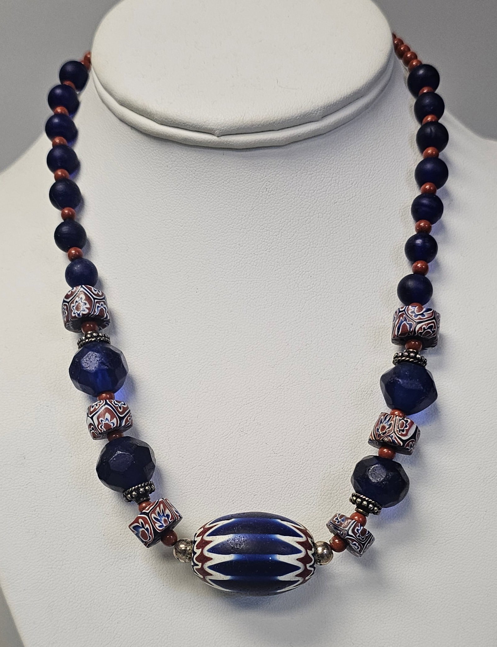 Sterling Venetian Chevron Glass Bead Necklace: An 18-inch necklace featuring blue faceted glass and Venetian chevron beads with a sterling silver hook clasp stamped 925. Good condition.