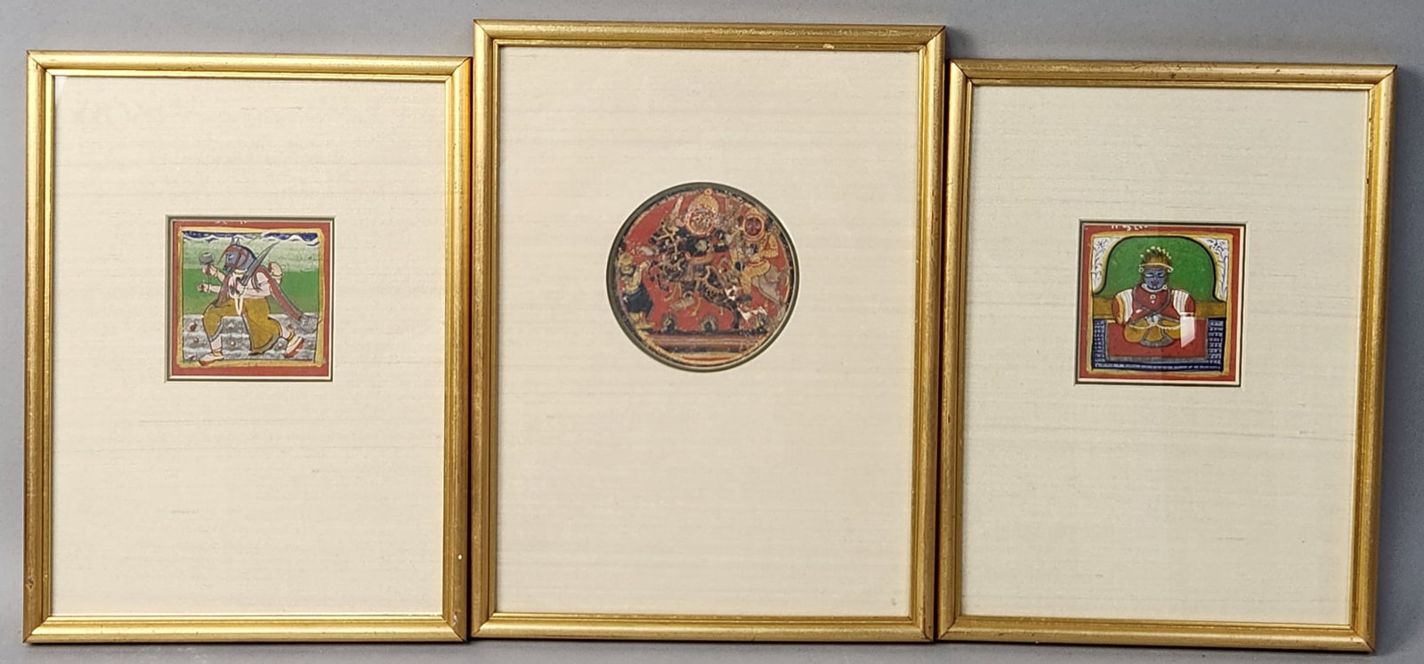 Indian Miniature Paintings: A trio of Indian miniature paintings executed in gouache and metallic pigments on paper in the Rajasthan or Central Indian Style. Frame: 12 inches (H) x 8.5 inches (W). The central circular painting