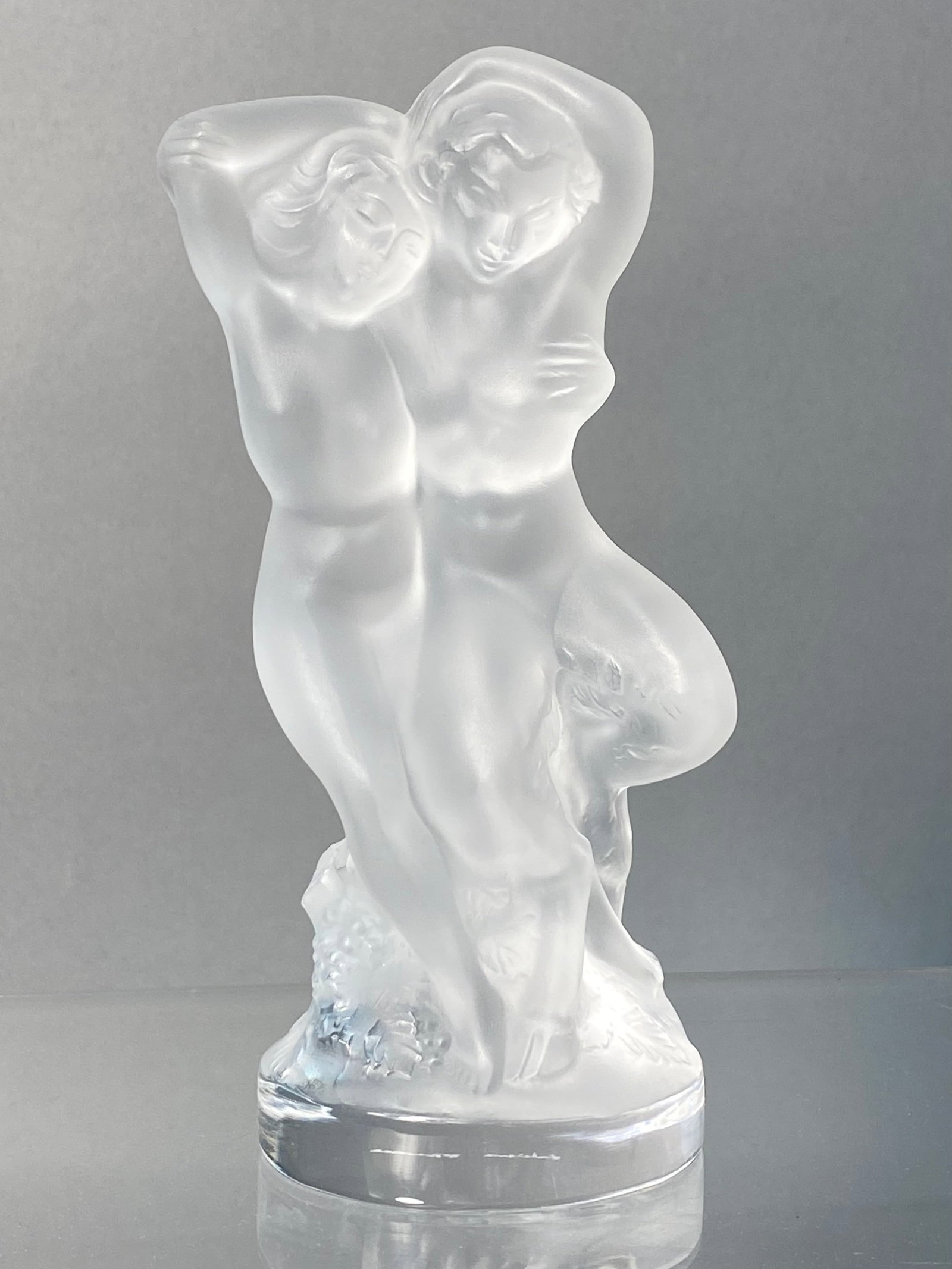 Lalique France Frosted Crystal Le Faune Figurine: A Lalique frosted and clear lead crystal sculpture titled Le Faune, also known as Deux Figurines. Originally designed by Marc Lalique in 1951, the piece depicts two intertwined nude figures, a male an