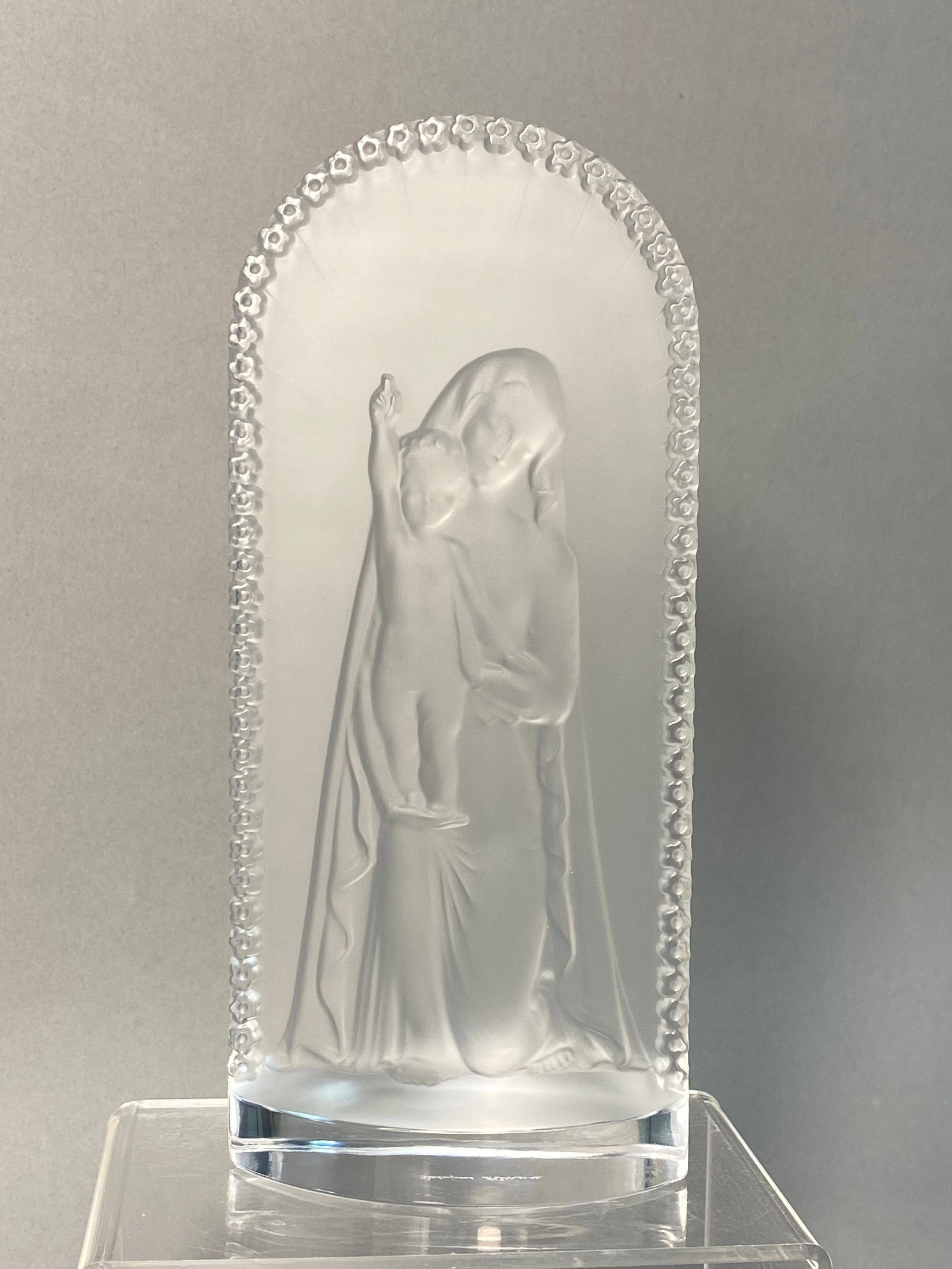 Lalique France Crystal Madonna & Child Plaque: A Lalique lead crystal plaque, referred to as the Kneeling Madonna or Vierge ? l'Enfant. The arched crystal piece features a central relief of the Virgin Mary holding the Christ Child, who is shown wi