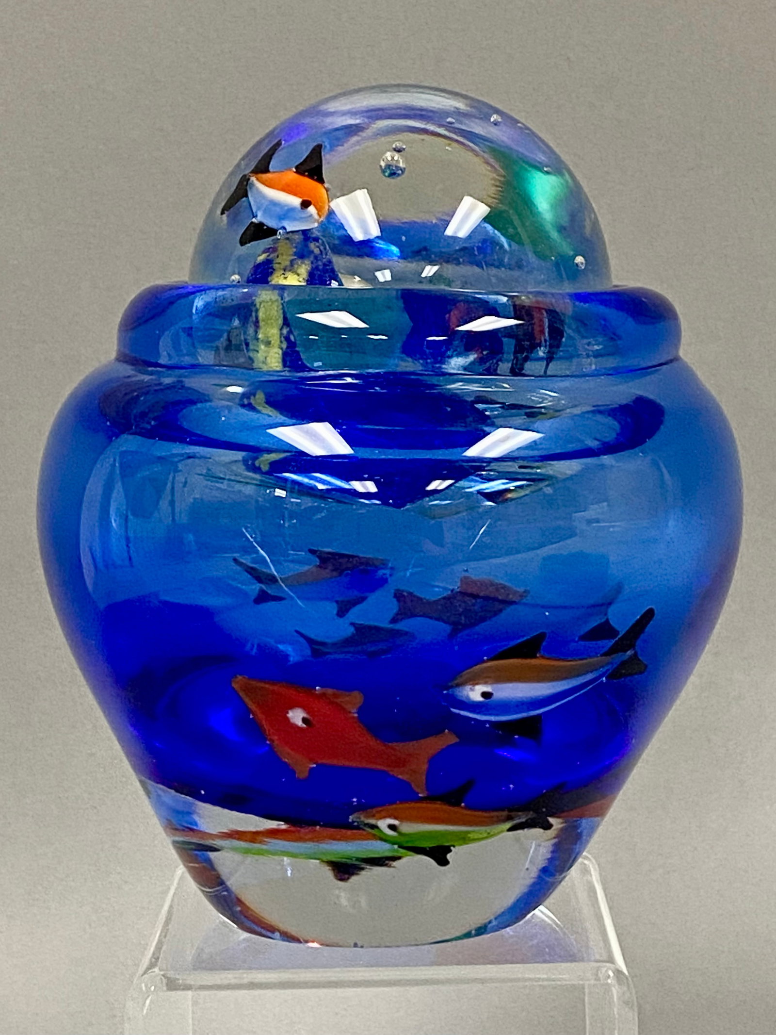 Cobalt Blue Sommerso Art Glass Aquarium Sculpture: A heavy, solid art glass sculpture crafted in the Murano style, depicting a vibrant underwater aquarium scene. The piece utilizes the sommerso technique, featuring a deep cobalt blue lower body that t