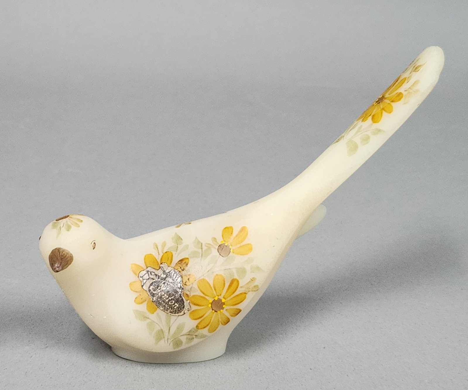 Fenton Custard Satin Glass Happiness Bird: This Fenton Art Glass figurine is a hand-painted Happiness Bird crafted in opaque custard glass with a matte satin finish. The base is inscribed in gold-tone paint with the signature Handpainted by Di