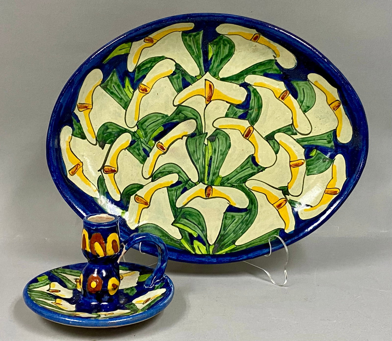 Mexican Alba Hand-Painted Pottery Calla Lily: This lot features two pieces of hand-painted Mexican earthenware pottery from the Alba studio. The set includes a large oval platter and a chamberstick, both decorated with a stylized Calla Lily motif