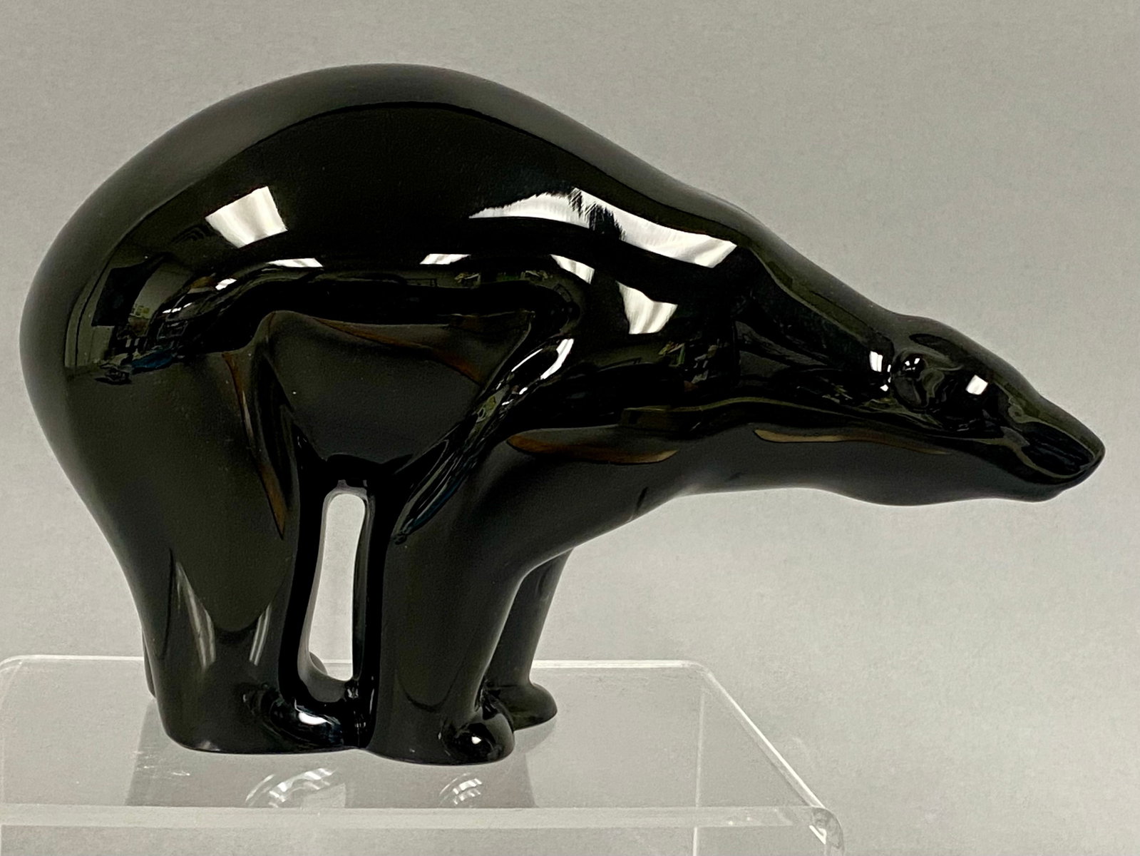 Baccarat Black Crystal Polar Bear Figurine: A stylized lead crystal figurine of a polar bear produced by Baccarat. The sculpture is fashioned from opaque black crystal with a highly polished, reflective finish. The figure is designed with minim