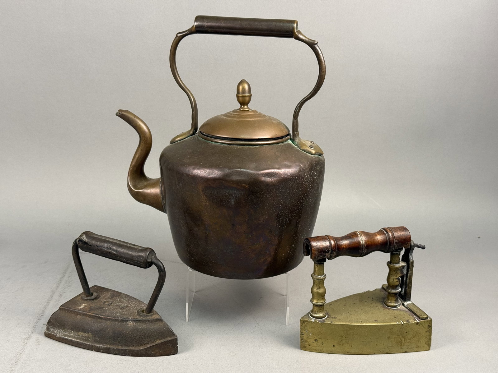 Antique Metalware Inc Copper Tea Kettle & 2 Irons: This lot consists of three antique domestic metalware items including a large tea kettle and two specialized irons. The tea kettle features a hand-hammered copper body with visible dovetailed (cramped