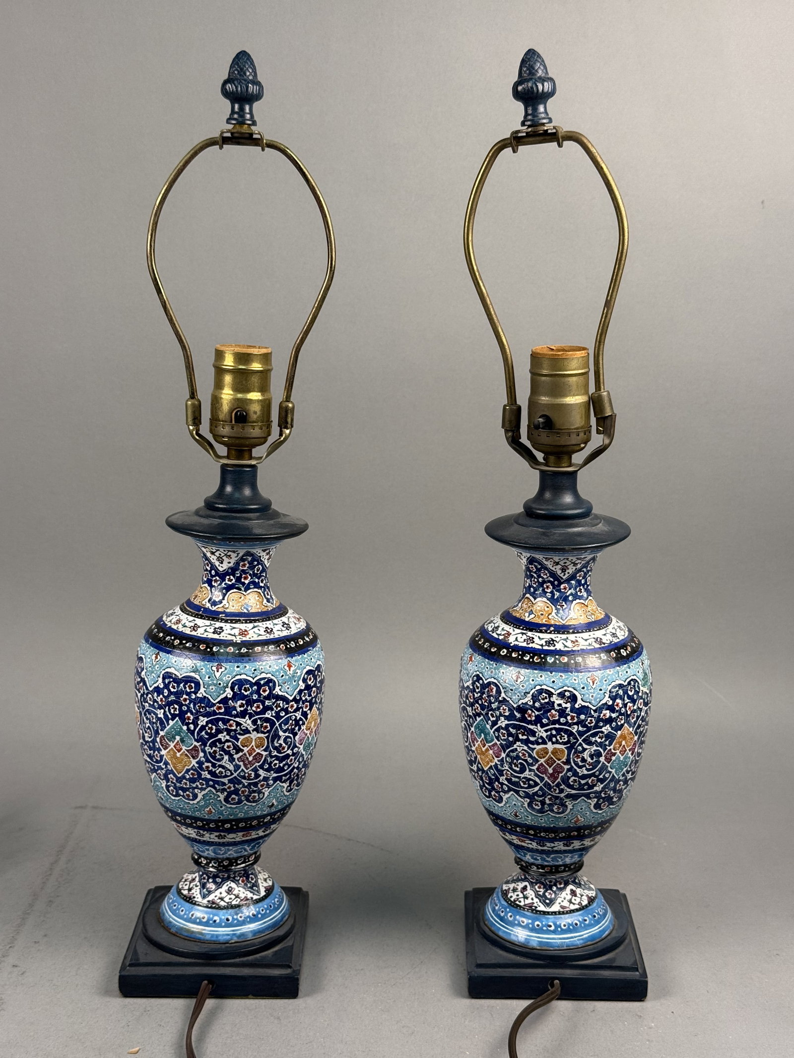Persian Style Enamel Ceramic Table Lamps: This pair of table lamps features baluster-form ceramic bodies decorated with hand-painted polychrome enamel in a traditional Persian style. The glazed ceramic surface displays a fine, uniform