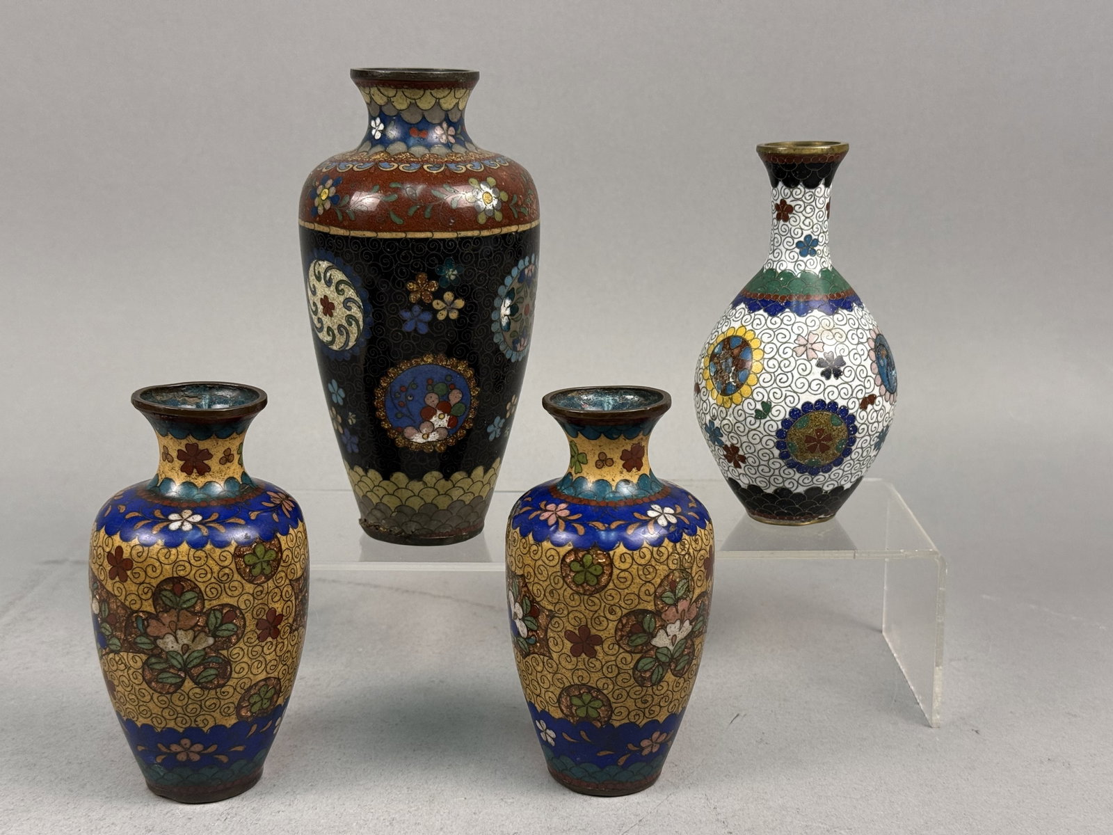 Japanese Cloisonne Enamel Cabinet Vases: An assortment of cloisonne enamel cabinet vases showcasing decorative motifs and techniques characteristic of the Japanese Meiji period. Each piece is constructed with a copper alloy body and