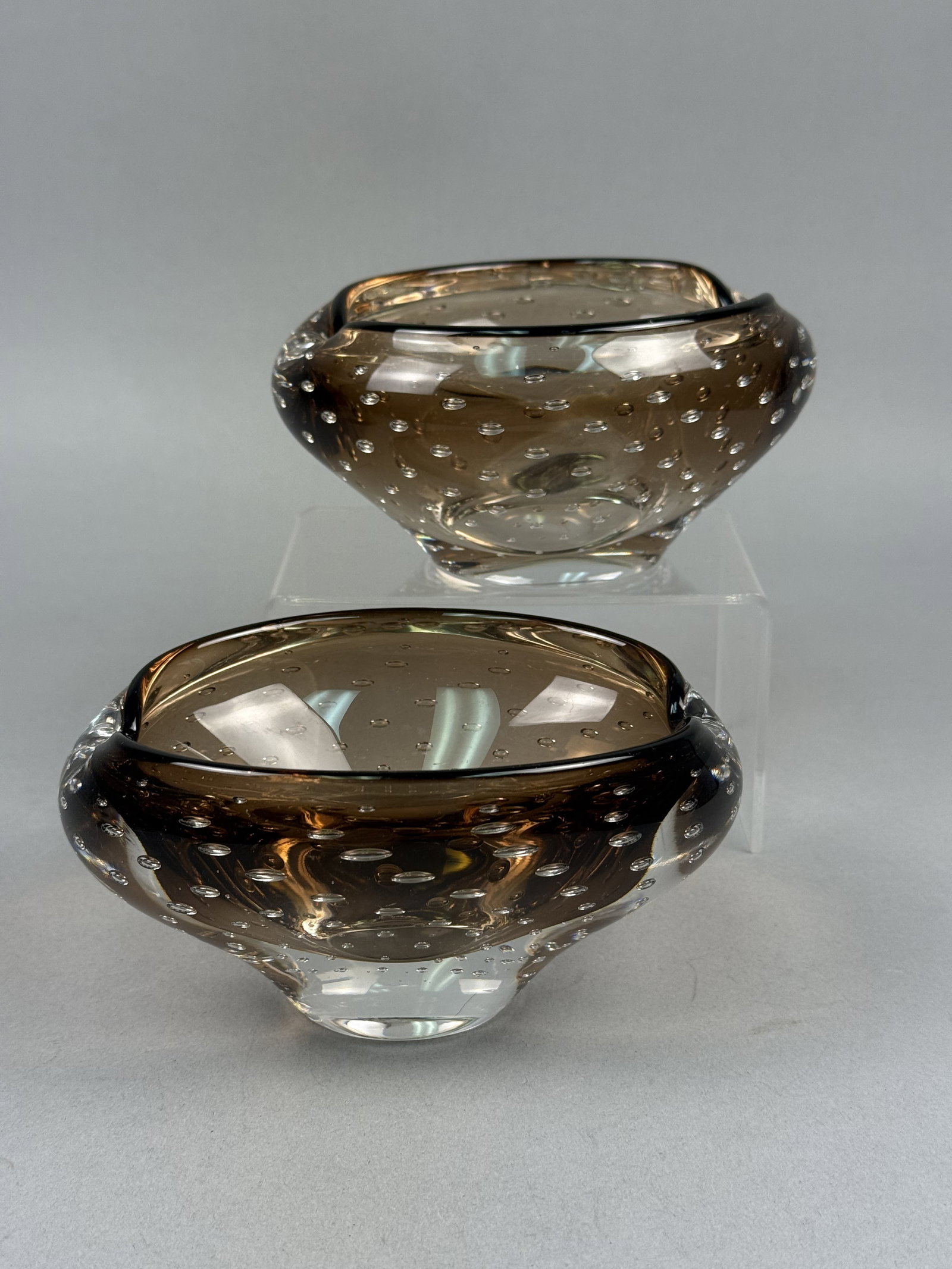 Murano Style Bullicante Art Glass Bowls: A pair of mid-century modern art glass bowls in the style of Murano glassmakers. These pieces are crafted from thick-walled, smoky brown translucent glass using the bullicante, or controlled bubble,