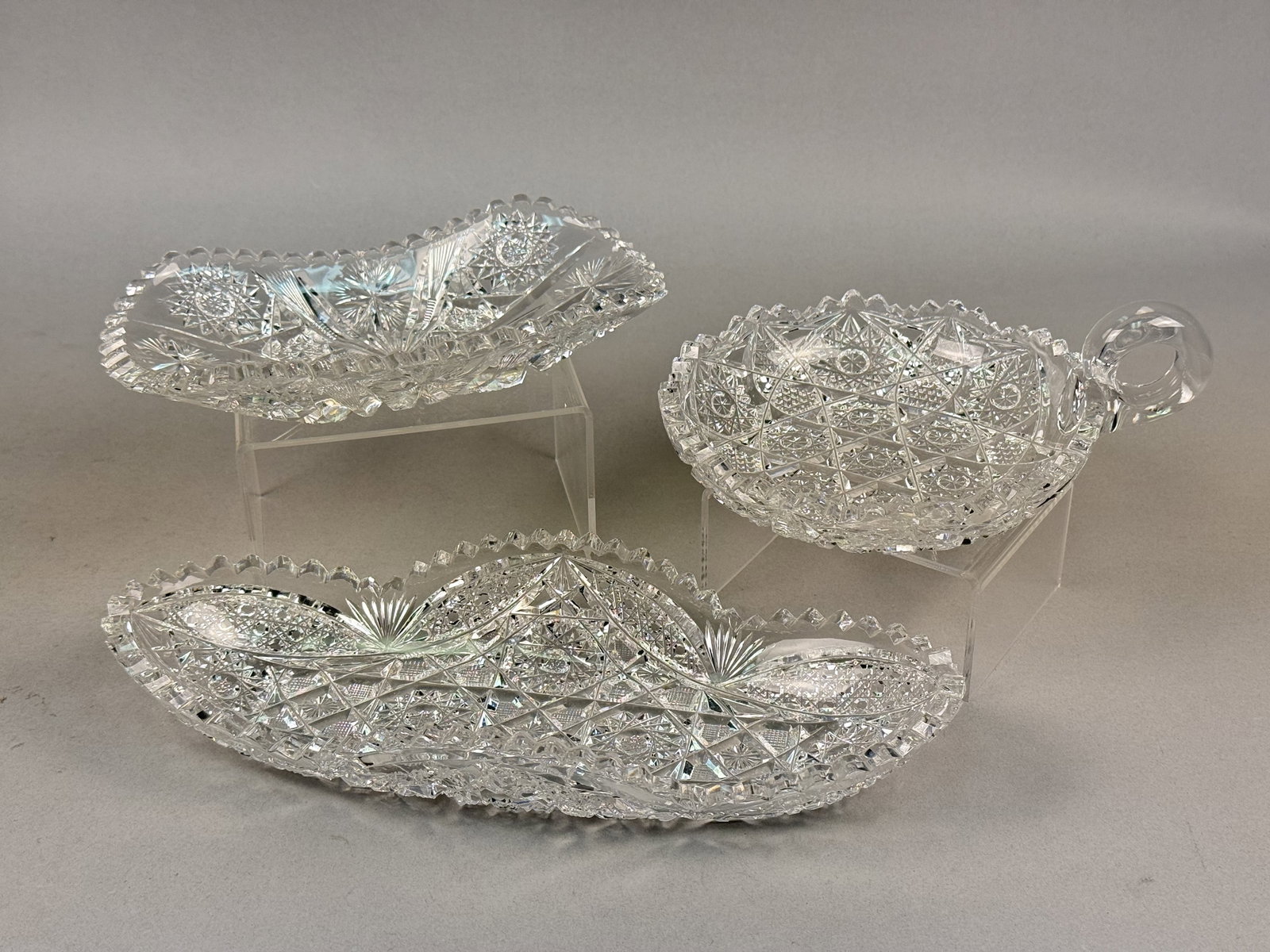 Brilliant Period Cut Glass Serving Dishes: This collection includes three pieces of colorless lead crystal in the American Brilliant Period style, featuring deep geometric intaglio cutting and sharp mitered edges. All three pieces feature