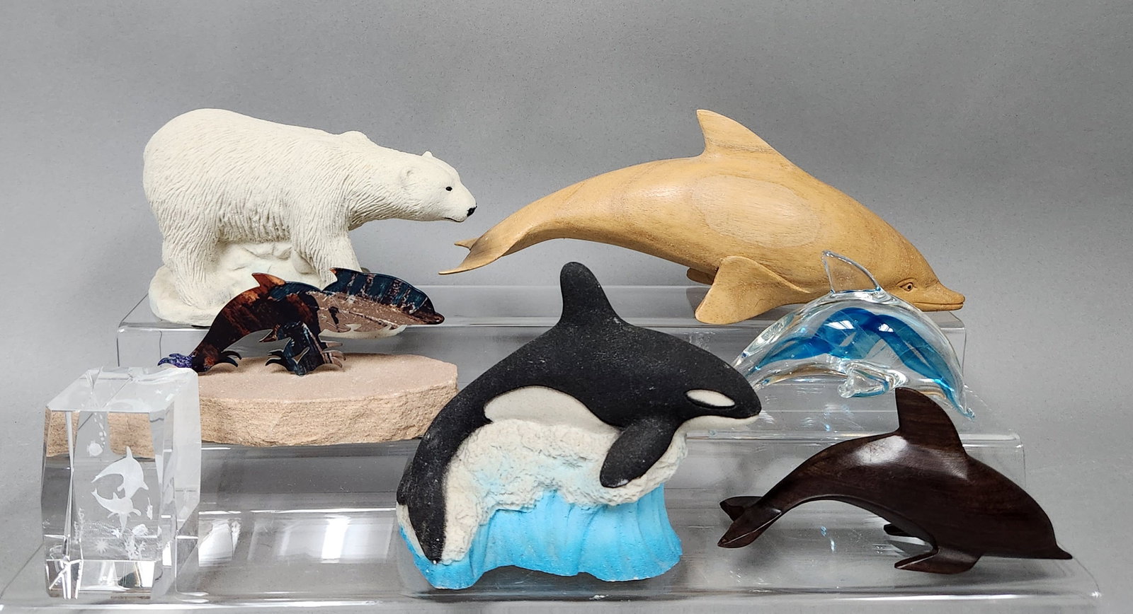 Assortment Marine & Arctic Animal Figurines: Polar bear: 6 inches length Large wooden dolphin: 11.5 inches length Small wooden dolphin: 6.5 inches length Glass dolphin: 6 inches length Orca figurine: 5 inches height Metal and stone sculpture: 6 