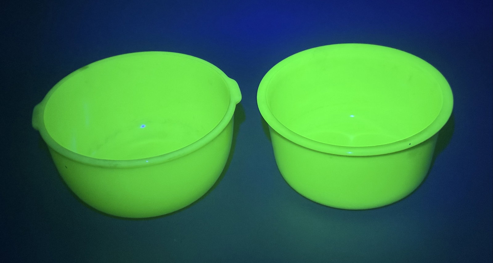 2 Vintage Jadeite Uranium Glass Mixer Bowls: This lot features a pair of mid-century opaque green glass bowls, commonly referred to as Jadeite. Both pieces are crafted from uranium glass, which produces a distinct and strong neon green fluoresce