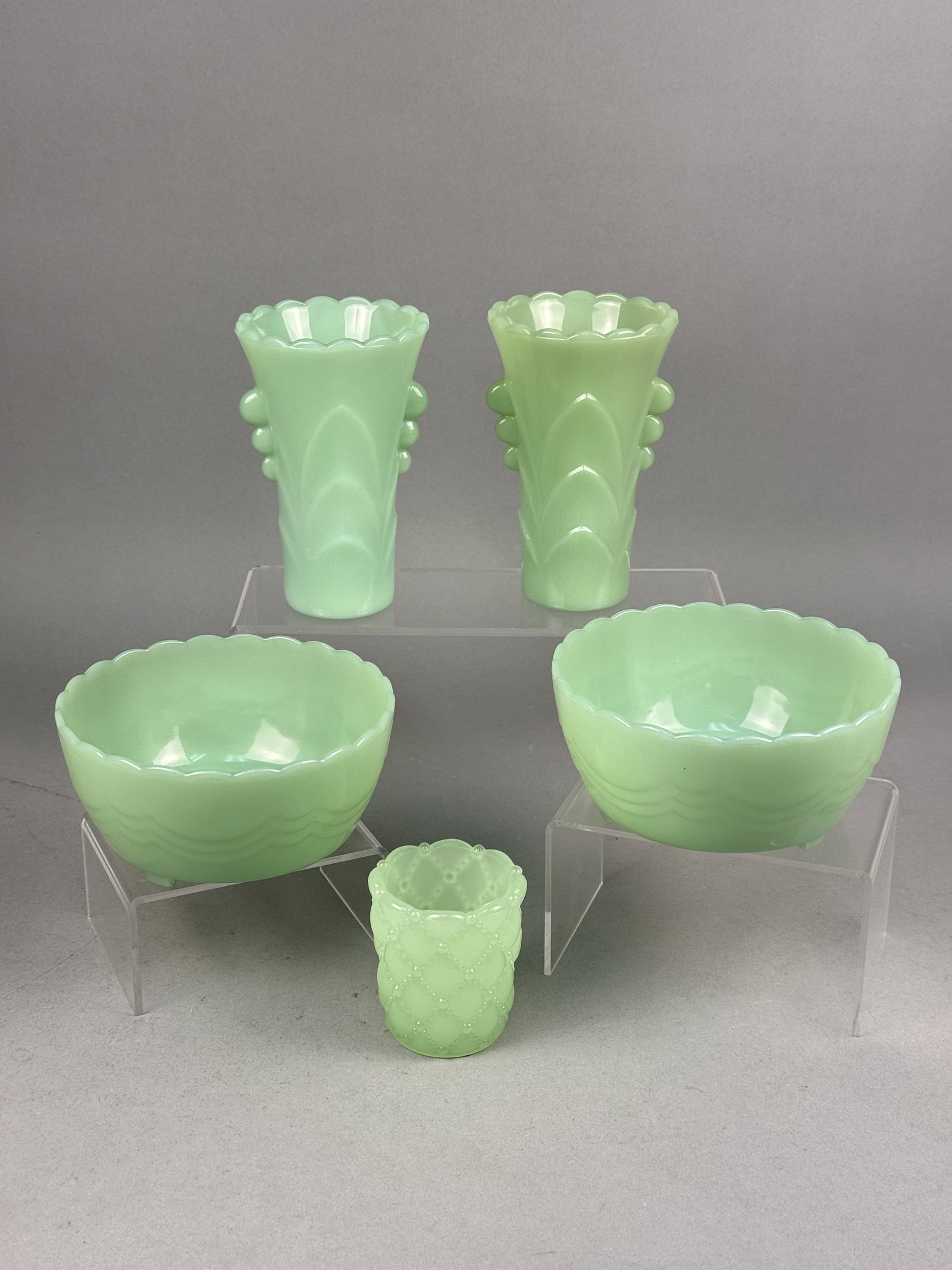 Fire-King Jadeite Glass Tableware: This lot comprises five pieces of mid-20th-century American jadeite glass, an opaque green milk glass produced by Anchor Hocking. The collection includes two Shell pattern bowls, which feature flared