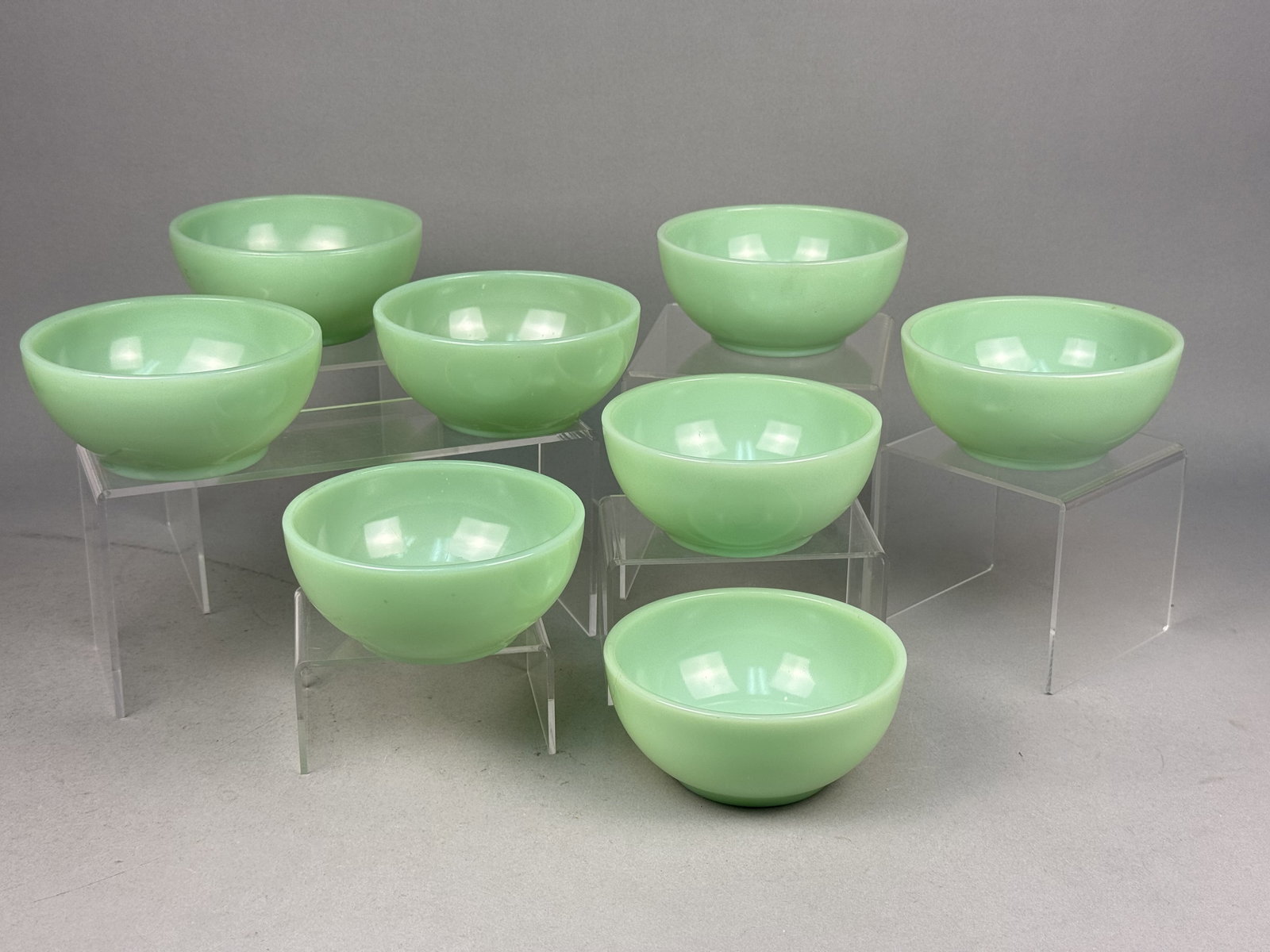 A Set of Vintage Jadeite Glass Chili Bowls: This collection of round, footed bowls is crafted from jadeite glass, an opaque, pale green milk glass. Based on the distinctive form and material, these items are attributed to Anchor Hocking for