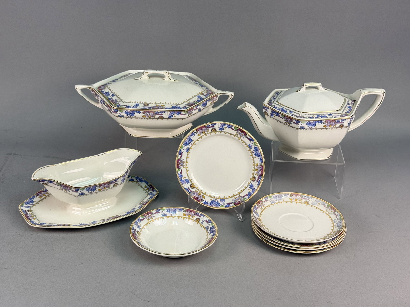 W.H. Grindley & Co. English Earthenware Table Service: This is a partial semi-porcelain earthenware table service produced by W.H. Grindley & Co. in England. Each piece features a distinctive octagonal form and is decorated with a multi-color transfer-pri