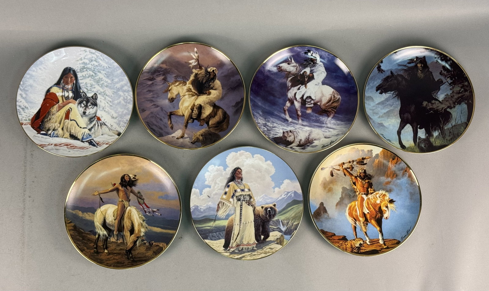 7 Native American Themed Plates by Franklin Mint & Hamilton: This lot features a collection of seven fine porcelain collector plates produced in the early 1990s. The reverse of each plate is marked with the series title, artist name, and a specific production n