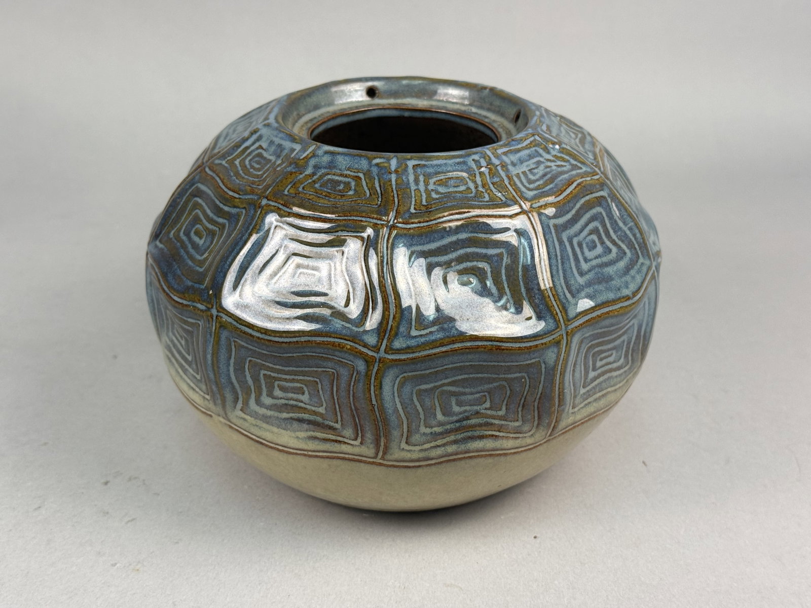 Mid-Century Modern Studio Pottery Stoneware Vessel: A studio pottery stoneware vessel of squat, globular form featuring a small circular aperture at the top. The upper two-thirds of the exterior is decorated with an impressed repeating pattern of neste