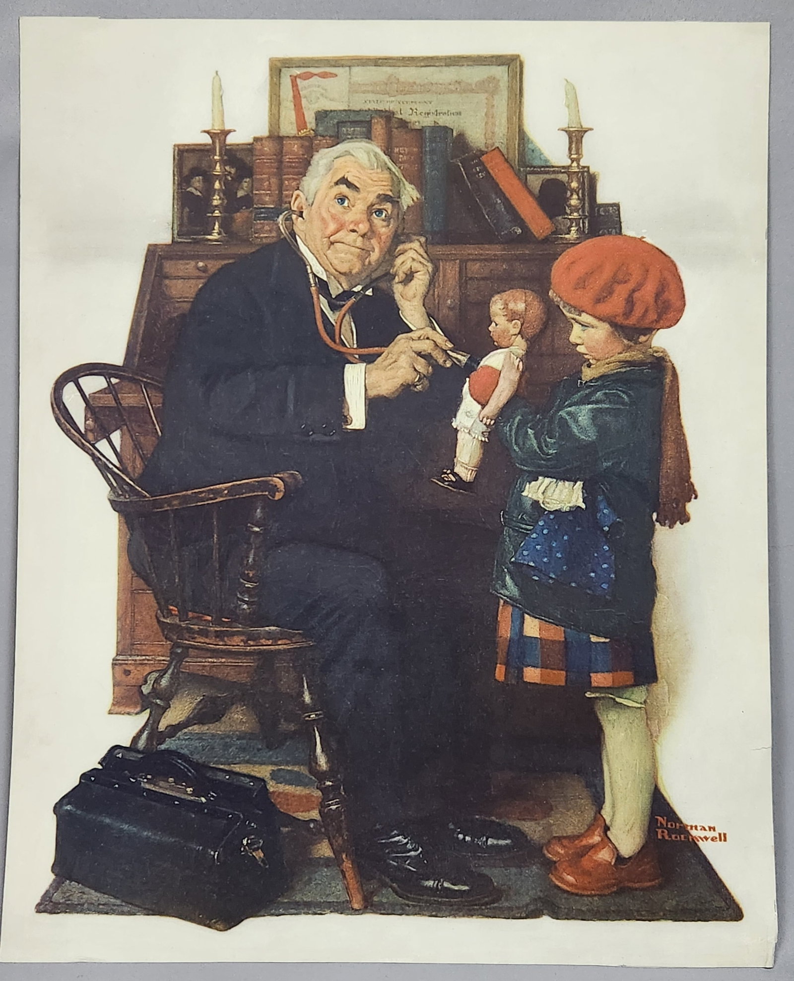 Norman Rockwell Doctor & Doll Print: A color art print on paper featuring Norman Rockwell's Doctor and the Doll with a printed signature, measuring approximately 27 by 22 inches. Good vintage condition. See pictures for condition.