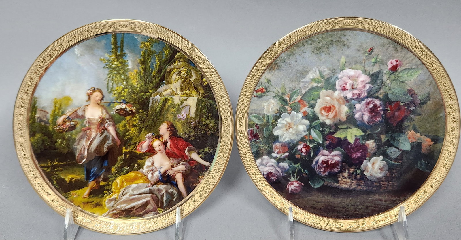 L'Etoile Limoges Porcelain Plates: A pair of circular decorative porcelain display plates manufactured by L'Etoile in Limoges, France. The first plate, titled Clochette en ete, depicts a pastoral Rococo-style garden scene. It shows a