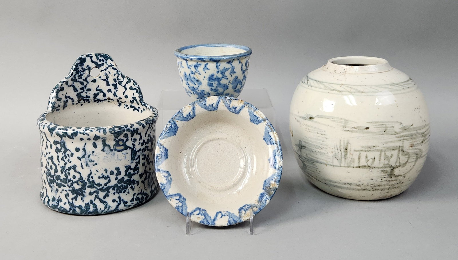 Blue Spongeware Ceramics & Hand-Painted Jar: This collection consists of several ceramic pieces, including a group of blue and white spongeware items and a hand-painted storage jar. The spongeware grouping includes a wall-hanging salt box, a cup