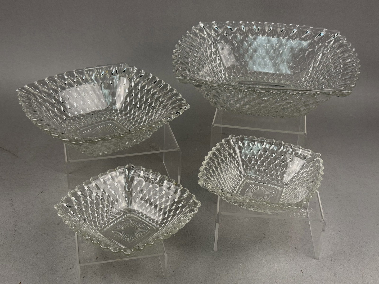 Indiana Glass Clear Diamond Point Square Bowls: This set of clear pressed glass bowls is identified as the Diamond Point pattern manufactured by Indiana Glass. Each bowl is square in form with a flared, scalloped rim and a dense molded
