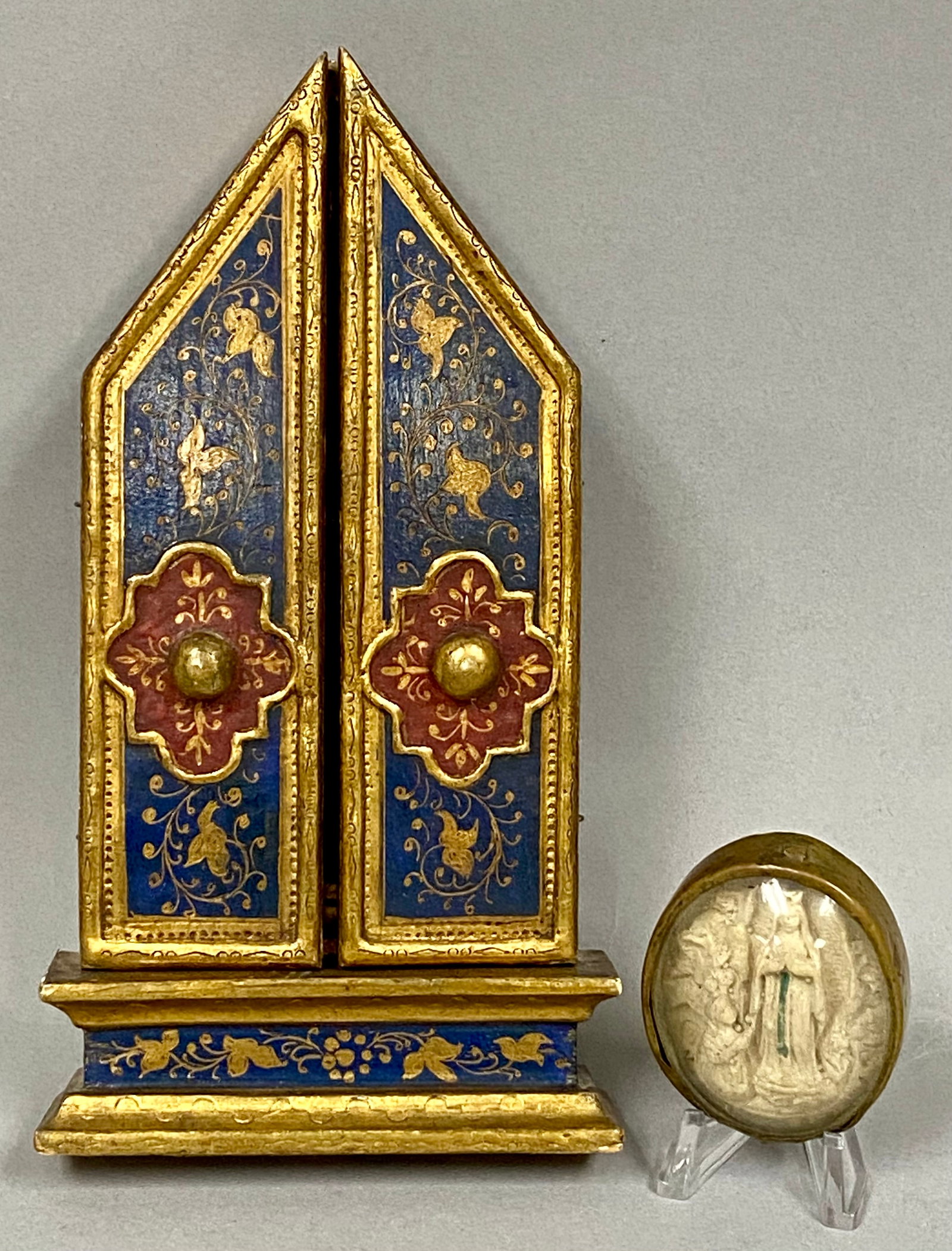 Italian Gilded Wood Triptych and Lourdes Relieff Plaque: This lot consists of two Catholic devotional objects. The primary piece is a miniature Italian triptych altarpiece made of painted and gilded wood. The central arched panel depicts Saint Francis of