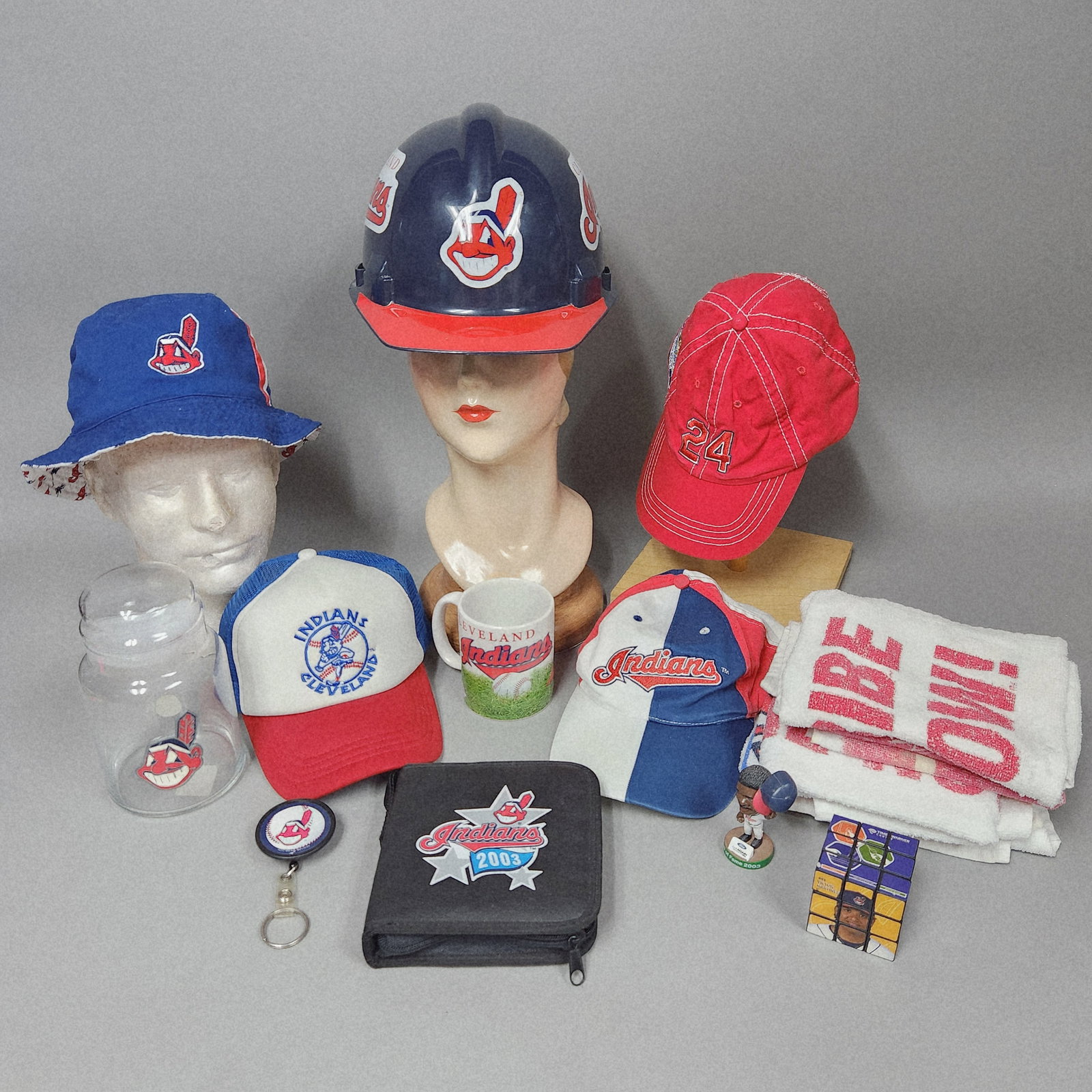 Cleveland Indians Baseball Memorabilia: This is an assortment of fan memorabilia from the Cleveland Indians baseball franchise, primarily featuring the team former Chief Wahoo logo and script branding. The group includes a navy blue plastic