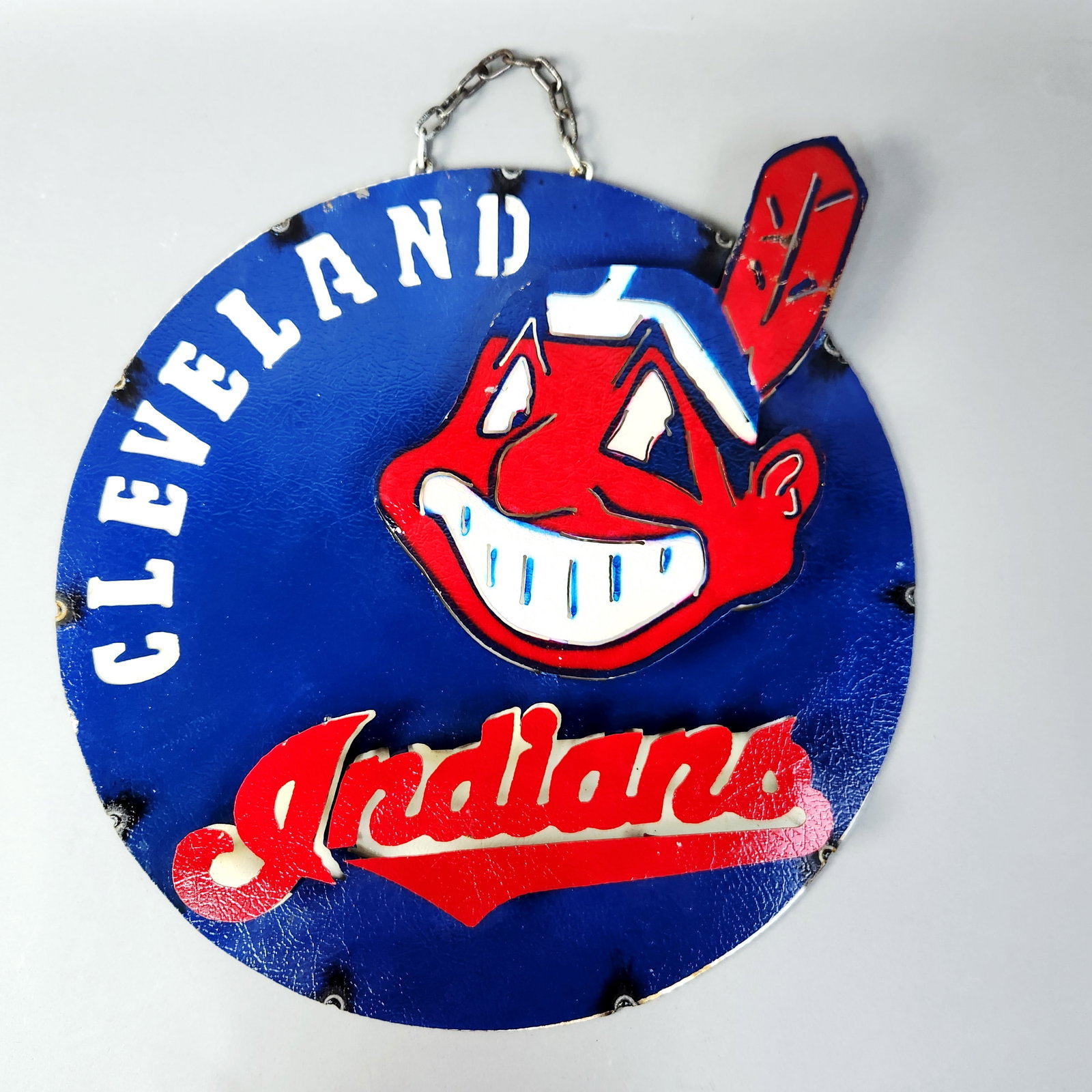 Cleveland Indians Chief Wahoo Metal Wall Sign: This handcrafted metal wall hanging features the vintage branding and mascot of the Cleveland Indians Major League Baseball team. The sign is constructed of multiple layers of cut metal welded