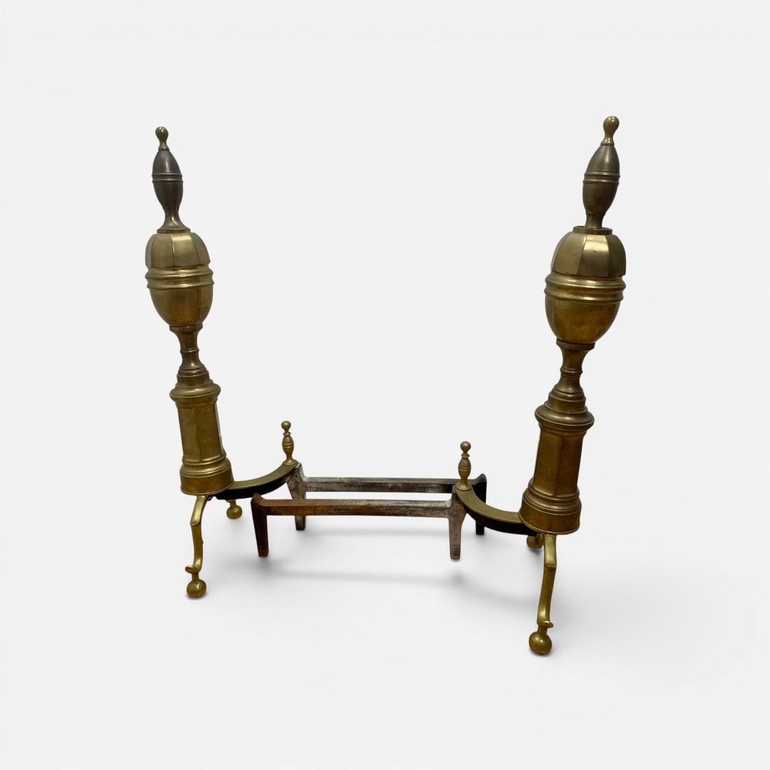 Federal Style Brass & Cast Iron Fireplace Andirons: A pair of fireplace andirons in the Federal or Neoclassical style. Each andiron features a decorative cast brass front assembly with an upright column composed of a faceted, octagonal urn-form section
